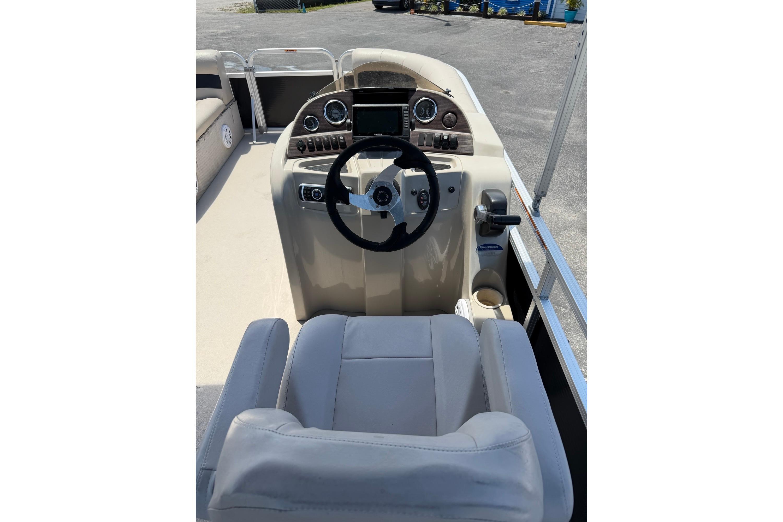 Steering console of a 2014 Avalon 1900 boat with modern controls and seating.