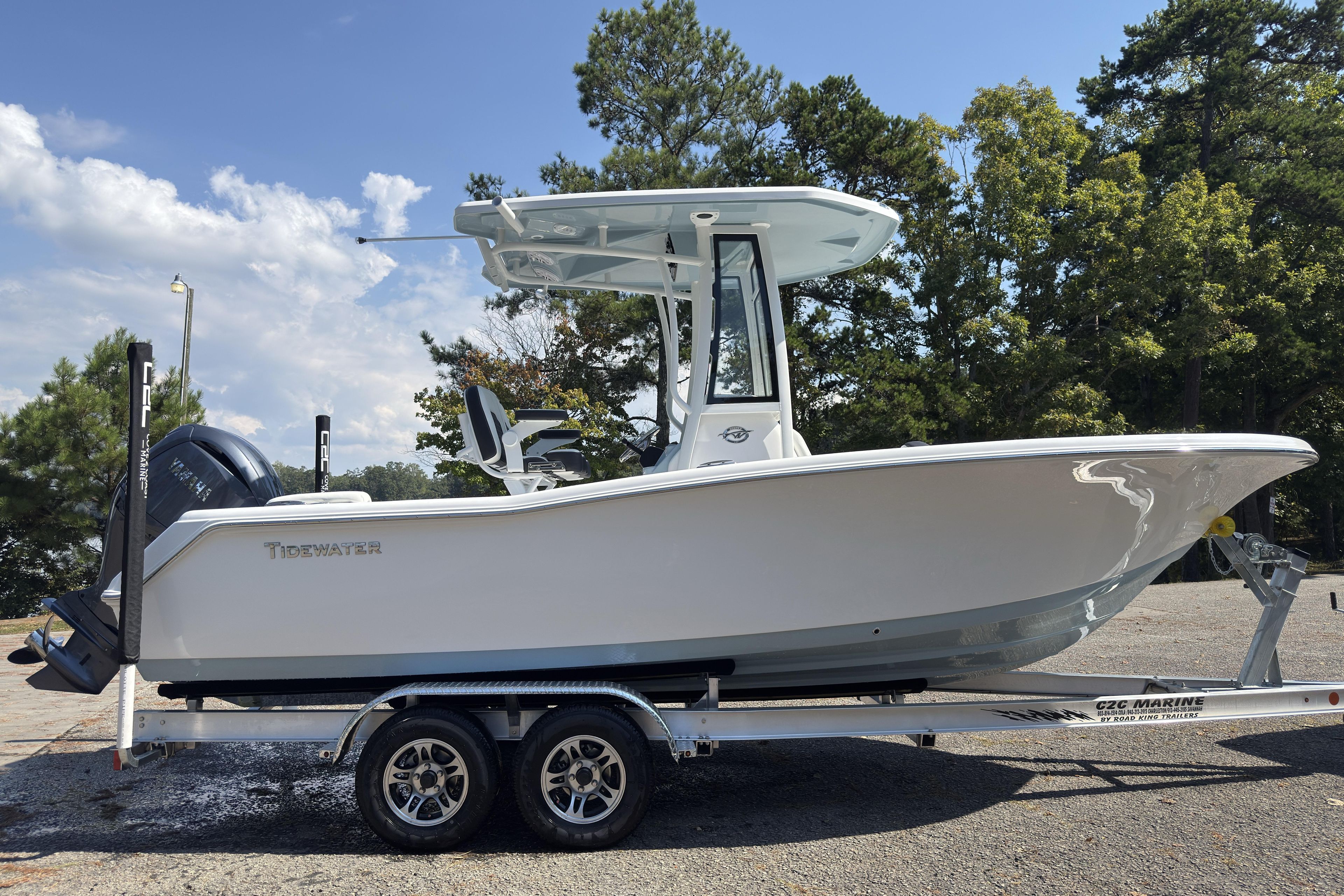 2026 Tidewater 220 LXF boat on trailer, parked outdoors with trees in background.