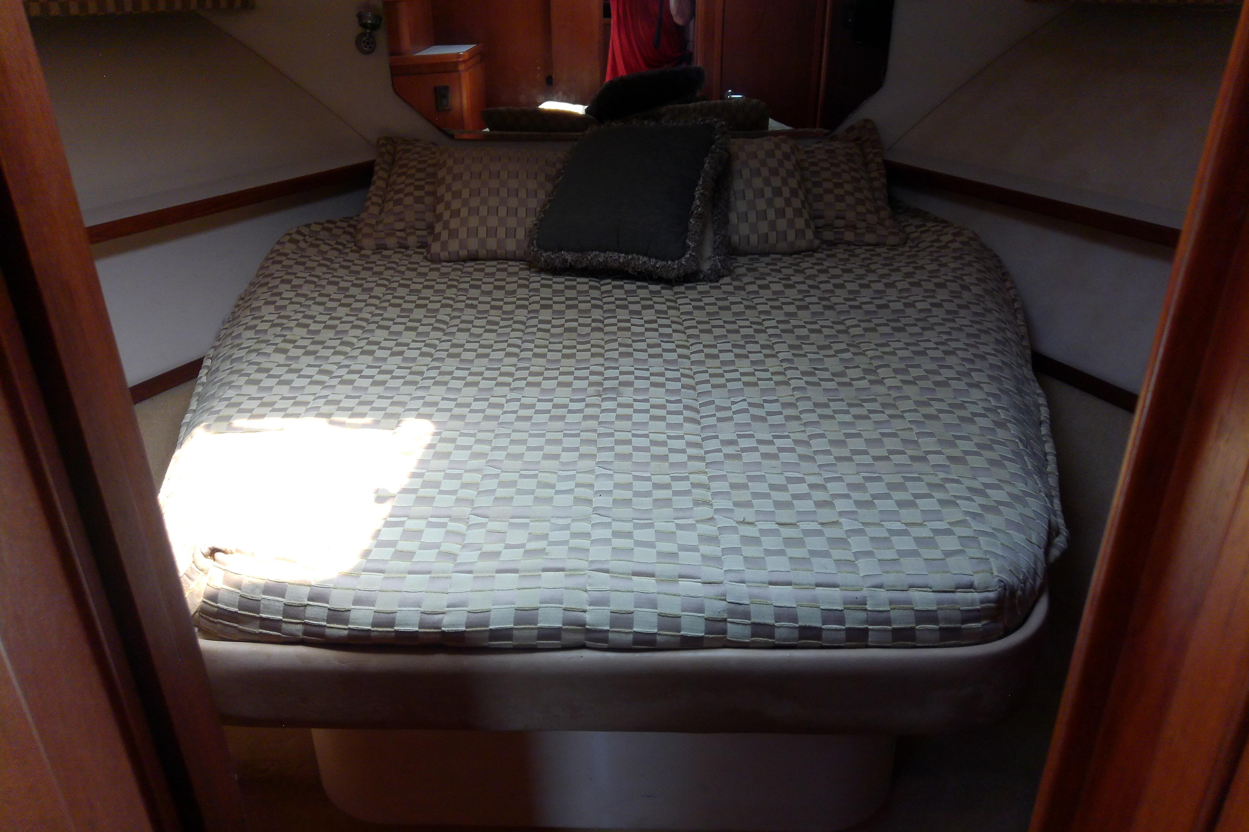 Interior cabin of 2000 Tiara Yachts 4100 Open with a cozy bed setup.