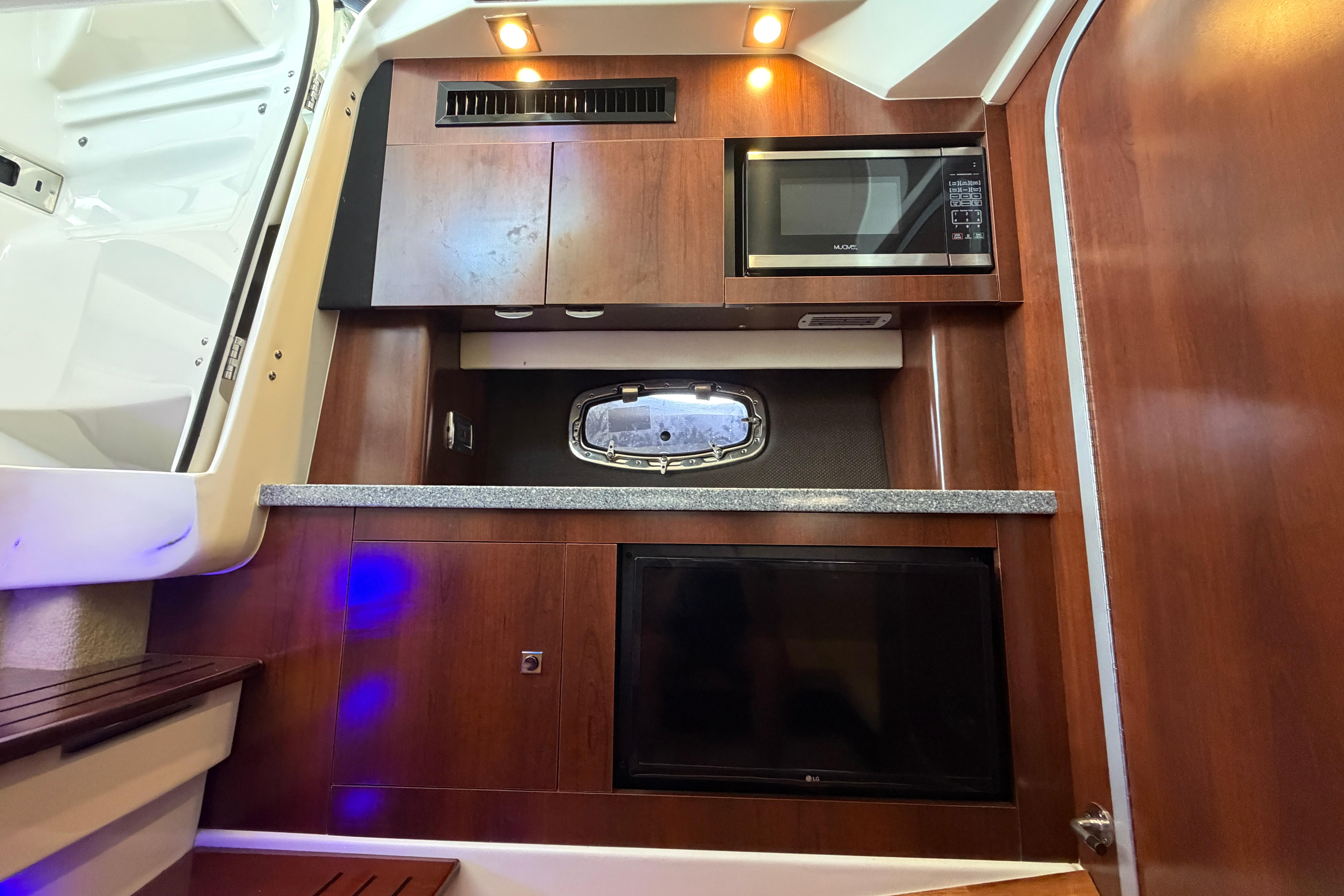 2018 Chaparral 347 SSX cabin interior with microwave, wood cabinetry, and modern lighting.