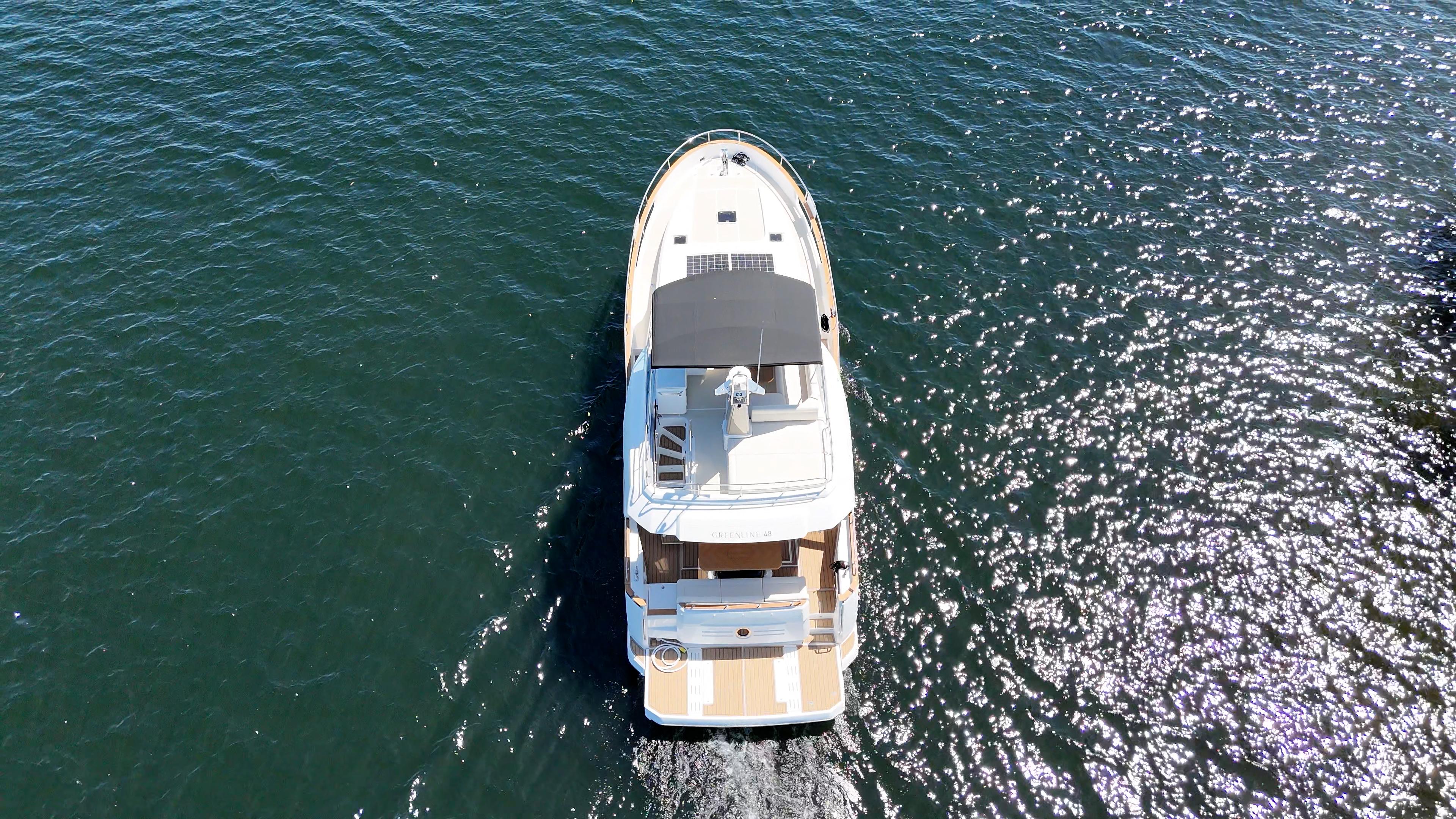 Aerial view of 2024 Greenline 48 Fly yacht cruising on open water.