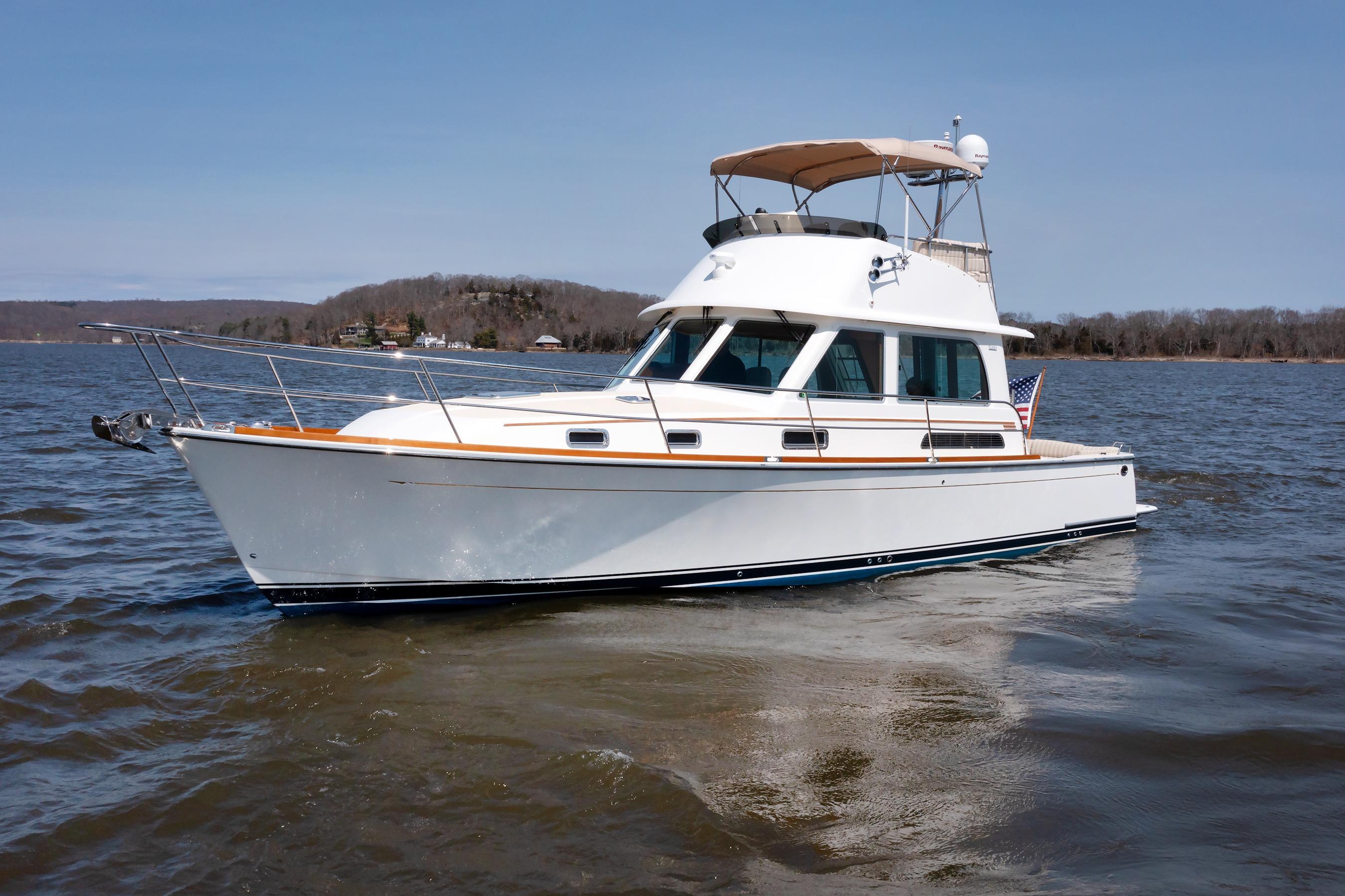 2016 Sabre 42 Fly Bridge Sedan cruising on a calm lake under clear skies.