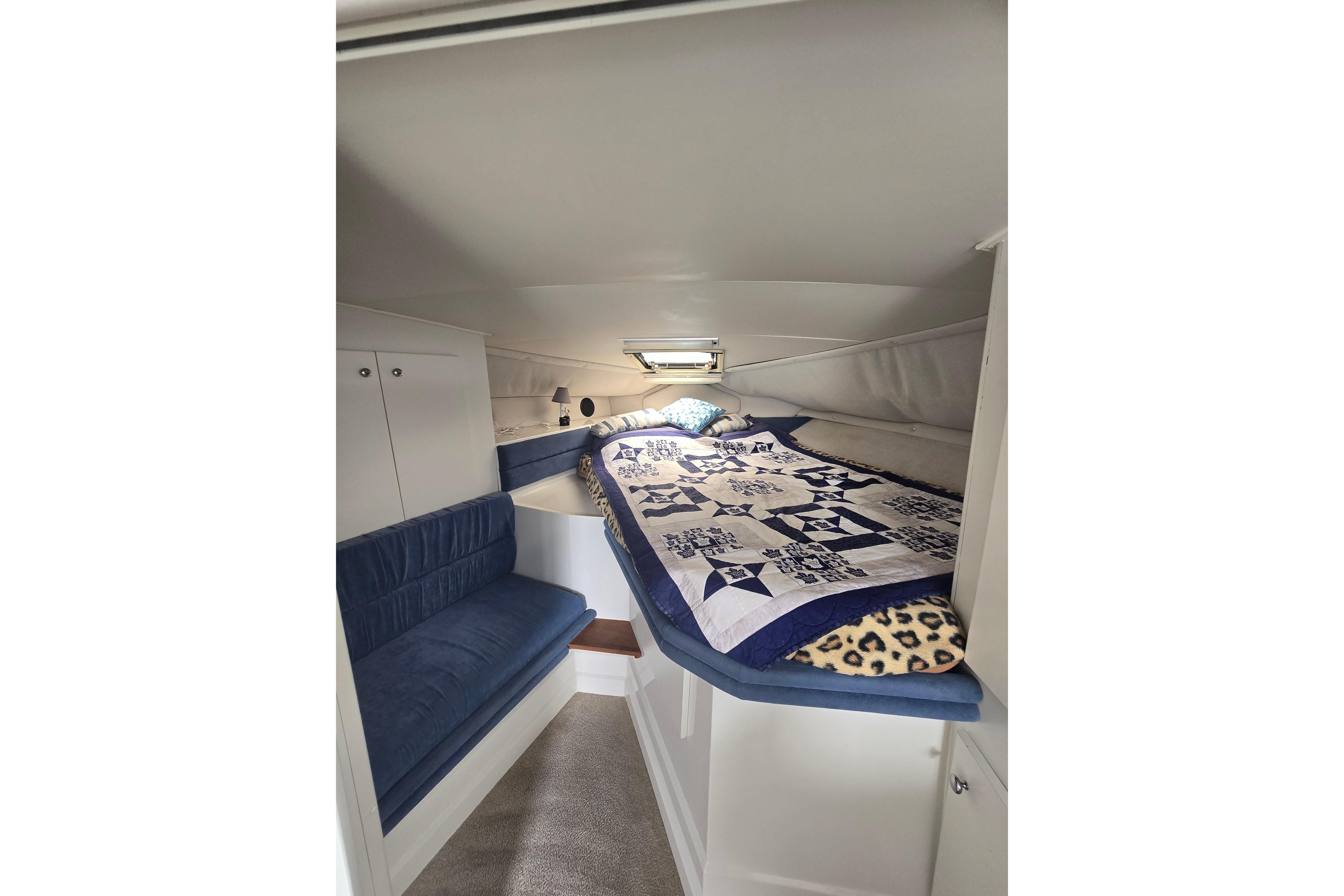 Cozy cabin interior of 1993 Carver 340 Santego with quilted bedding and seating.
