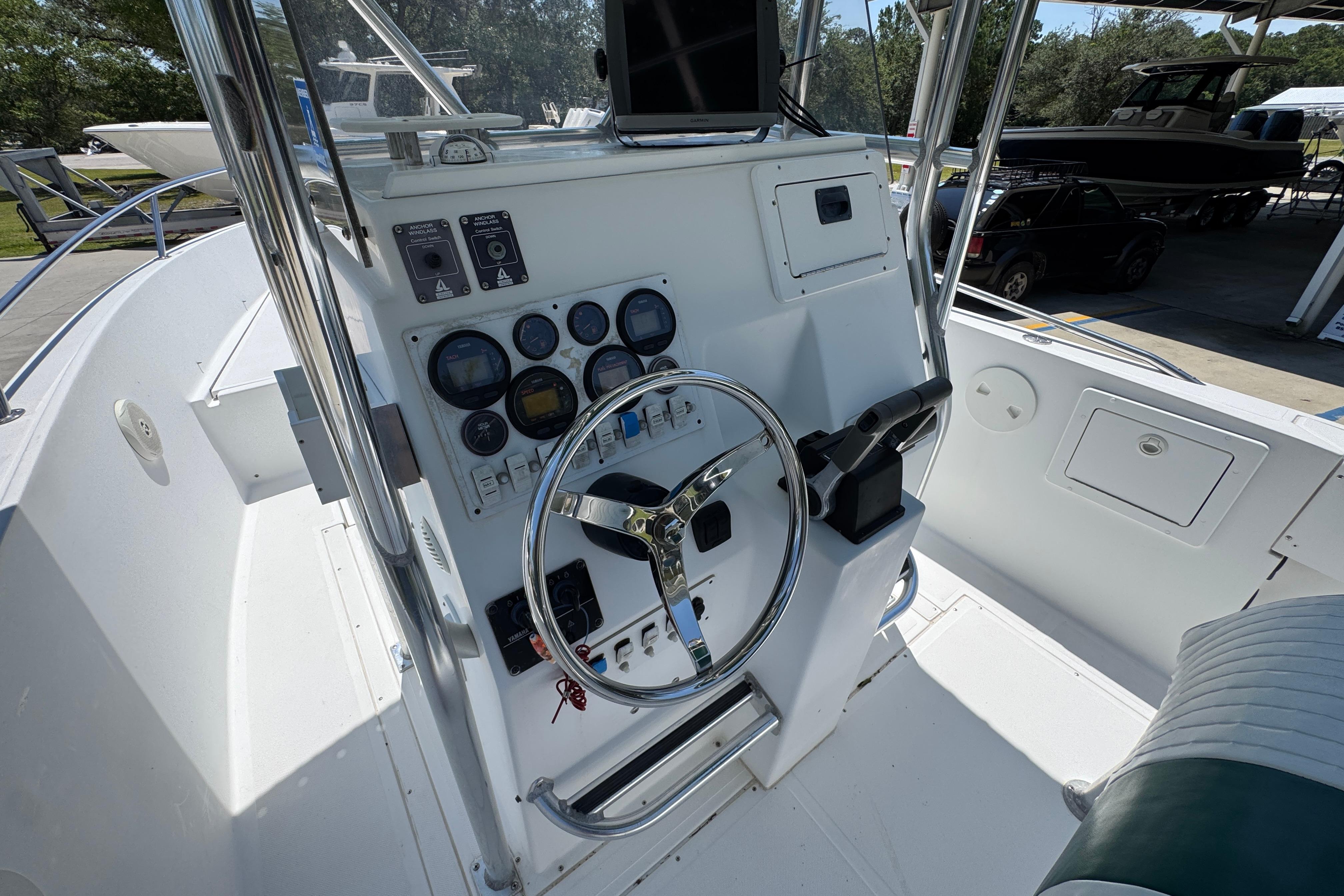 Center console of a 2000 Stamas 250 Tarpon boat with steering wheel and gauges.