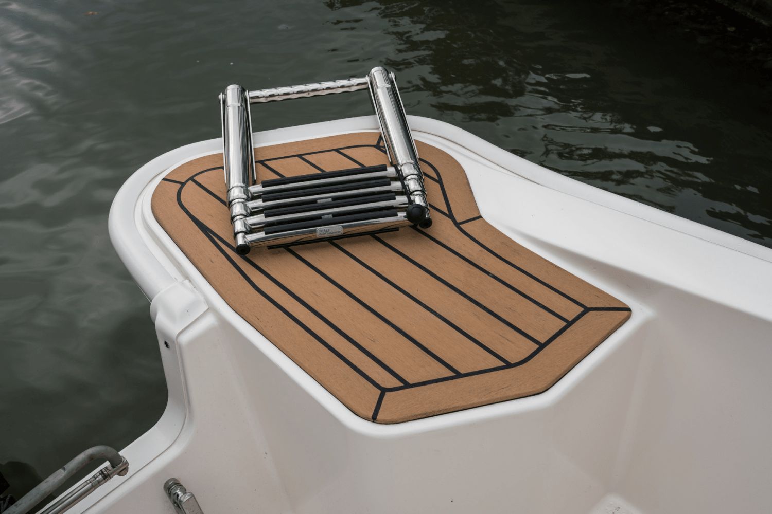 A swim platform with a foldable ladder on a boat.