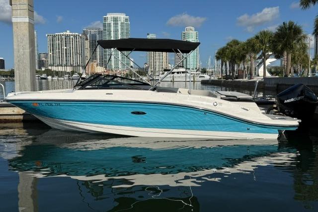 2022 Sea Ray SPX 210 Outboard boat docked in a marina with city skyline.