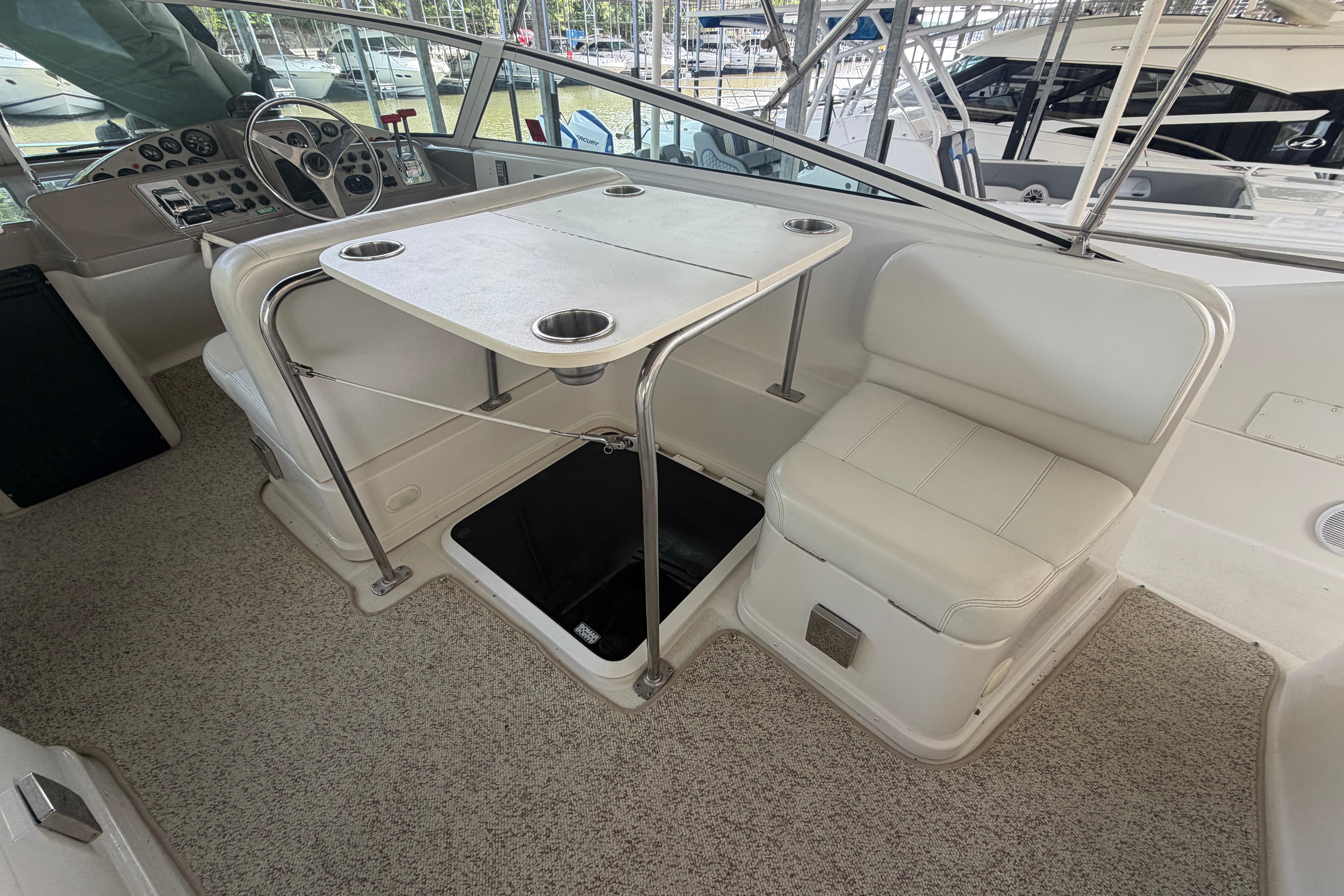 2000 Carver 350 Mariner interior with helm, seating, and table in a marina setting.