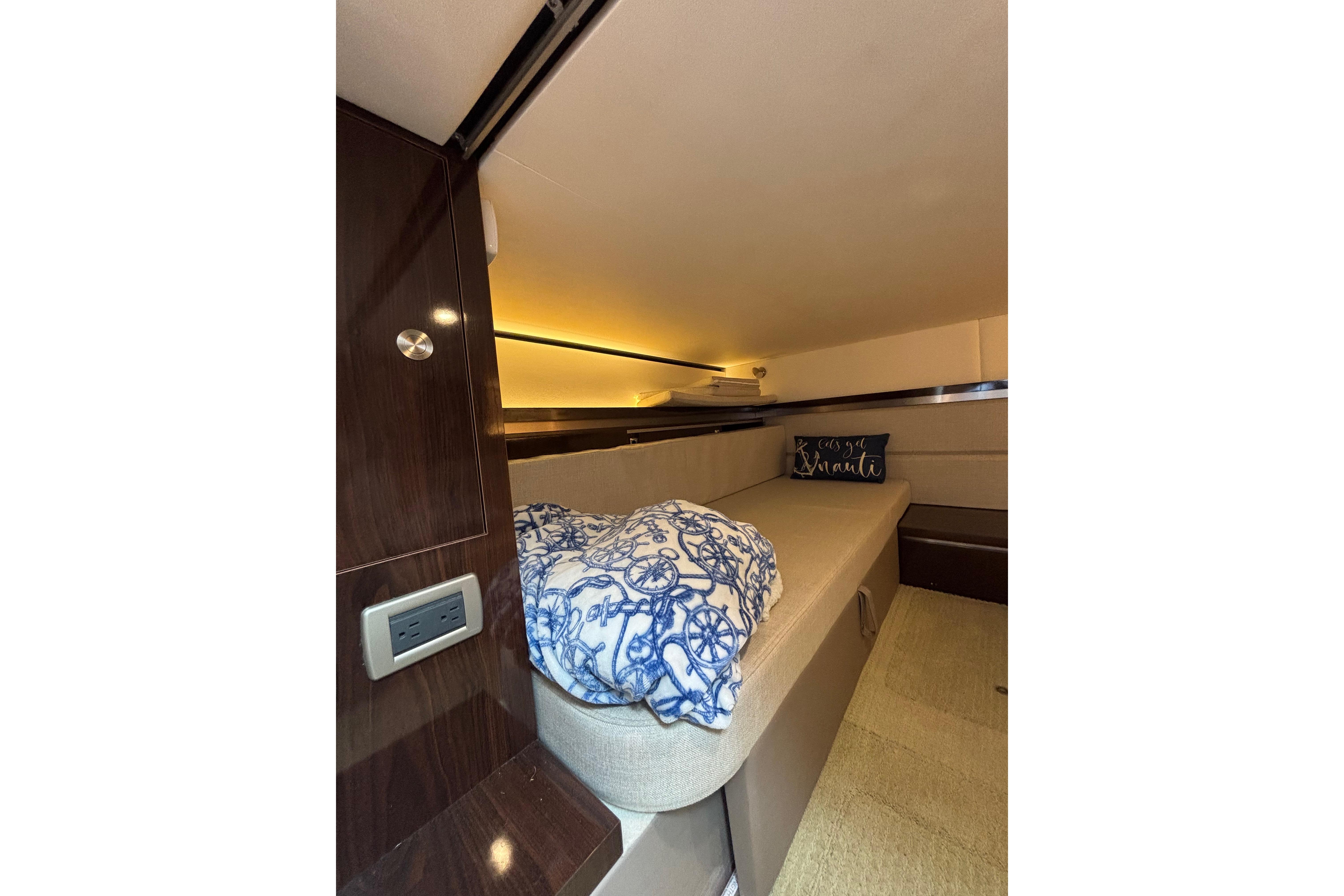 2021 Sea Ray Sundancer 320 Outboard cabin interior with cozy bedding and ambient lighting.