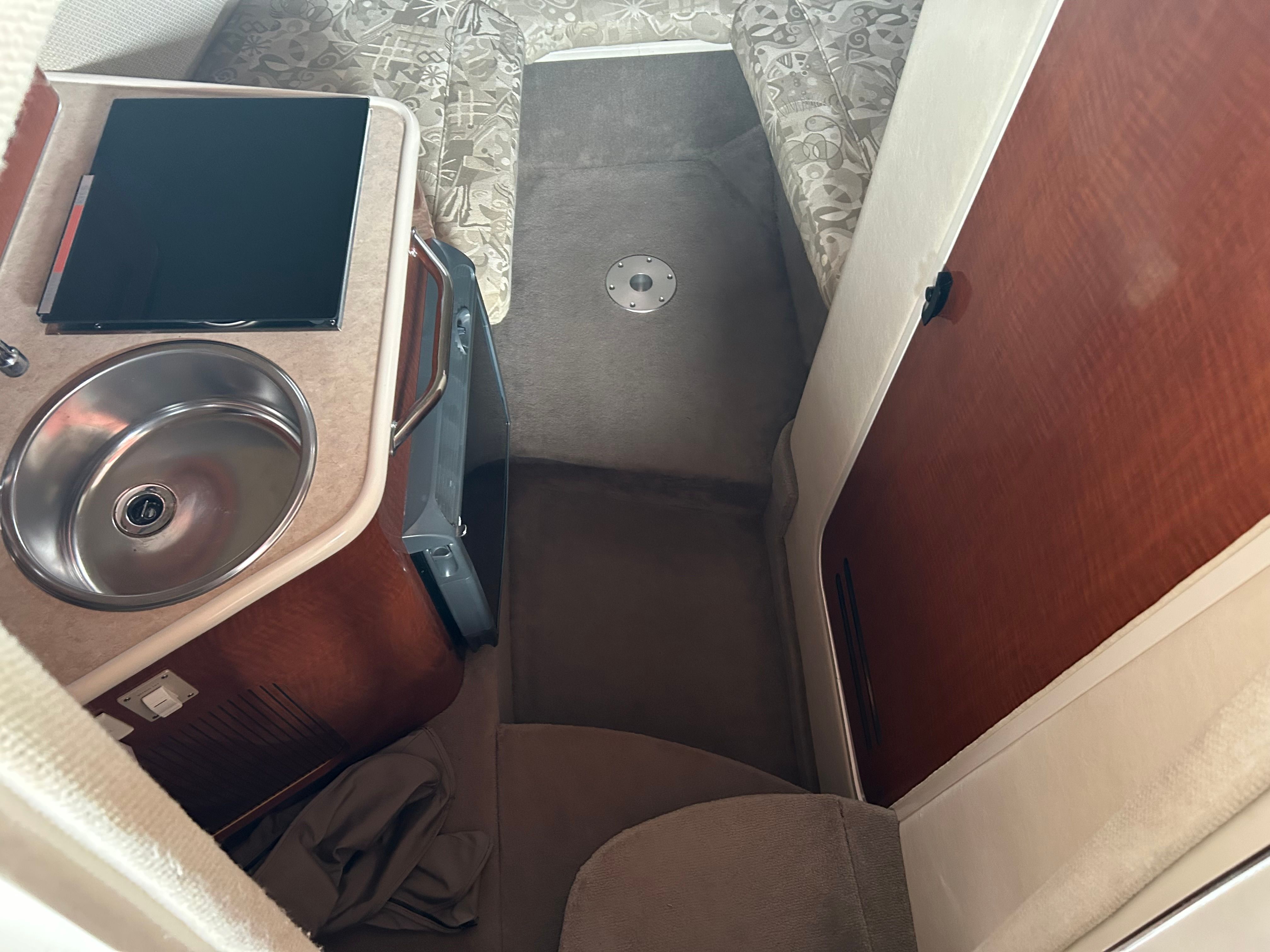 Interior of 2003 Sea Ray 240 Sundancer with sink, countertop, and cushioned seating.