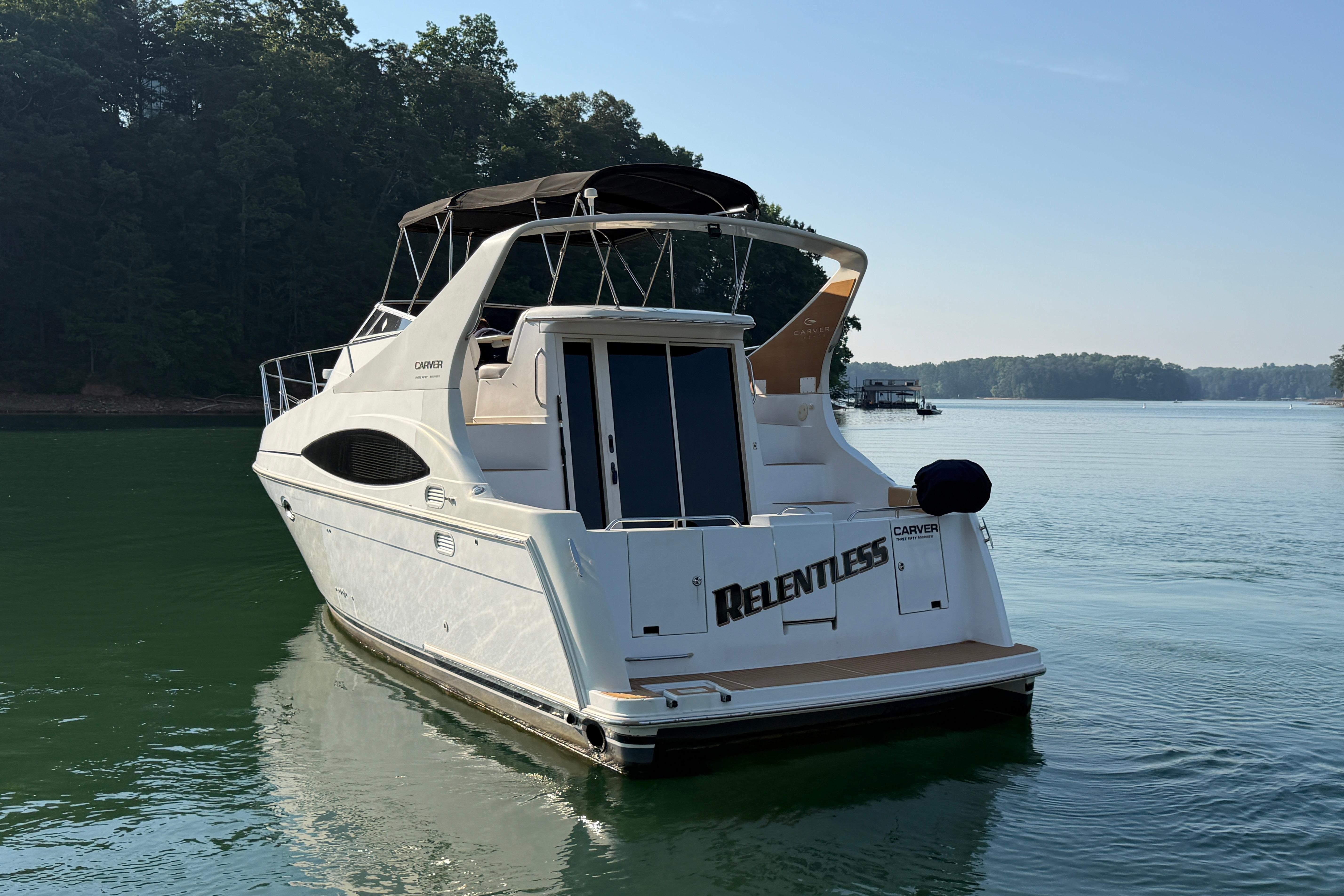 2003 Carver 350 Mariner yacht named "Relentless" on serene lake waters.