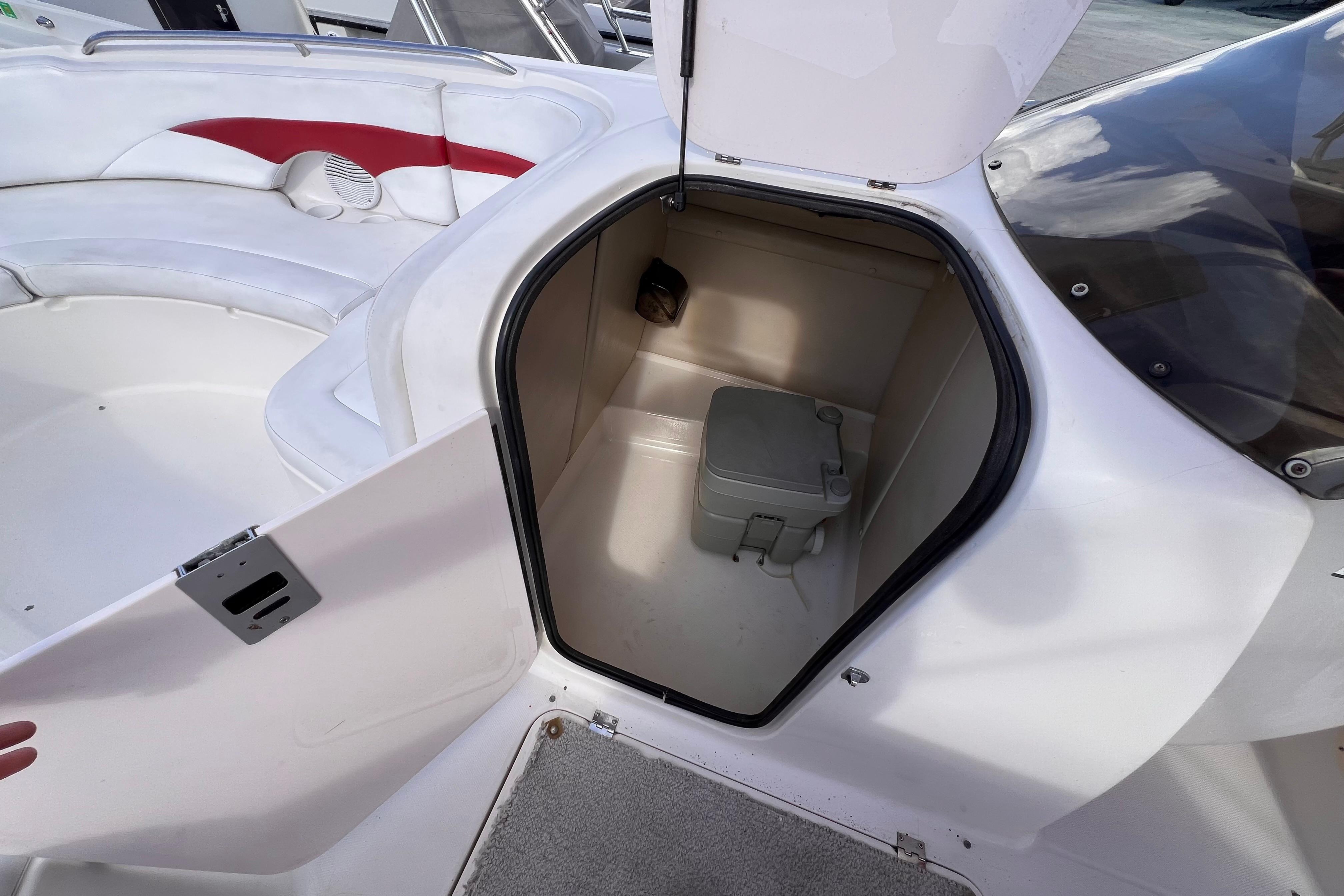 2002 Chaparral 232 Sunesta boat interior with open storage compartment and seating area.