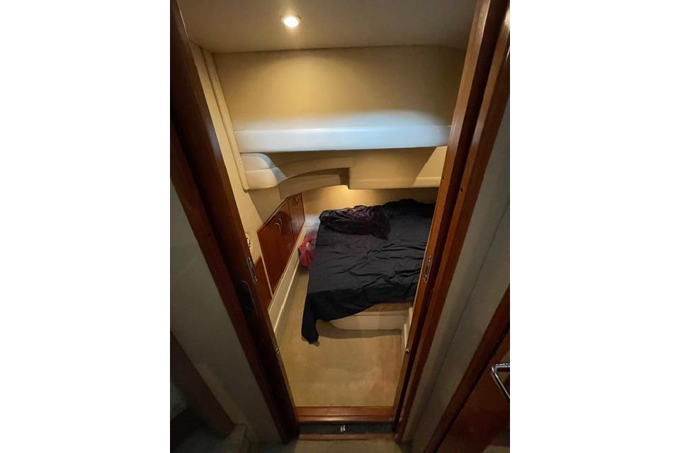 Cozy cabin interior of 2003 Carver 36 Super Sport yacht with bed and lighting.