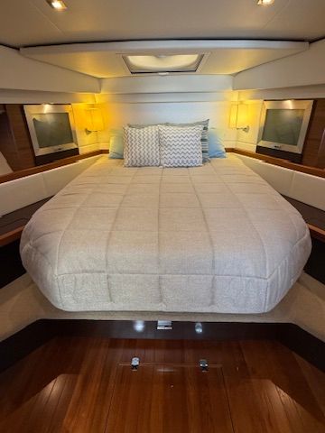 The image shows a cozy cabin with a large bed and soft pillows.
