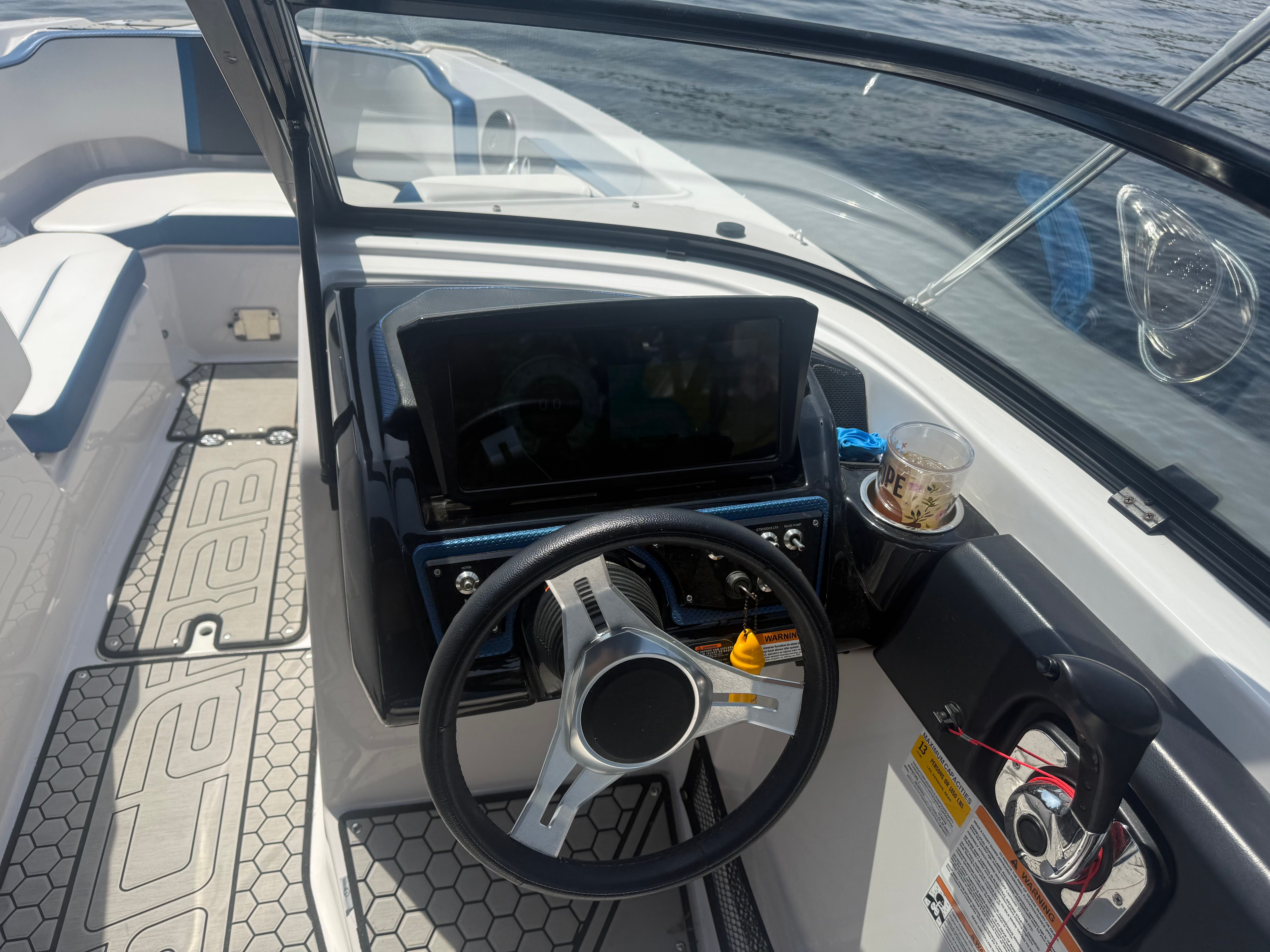 The cockpit of a 2018 Scarab 255 HOI boat with steering wheel and control console.