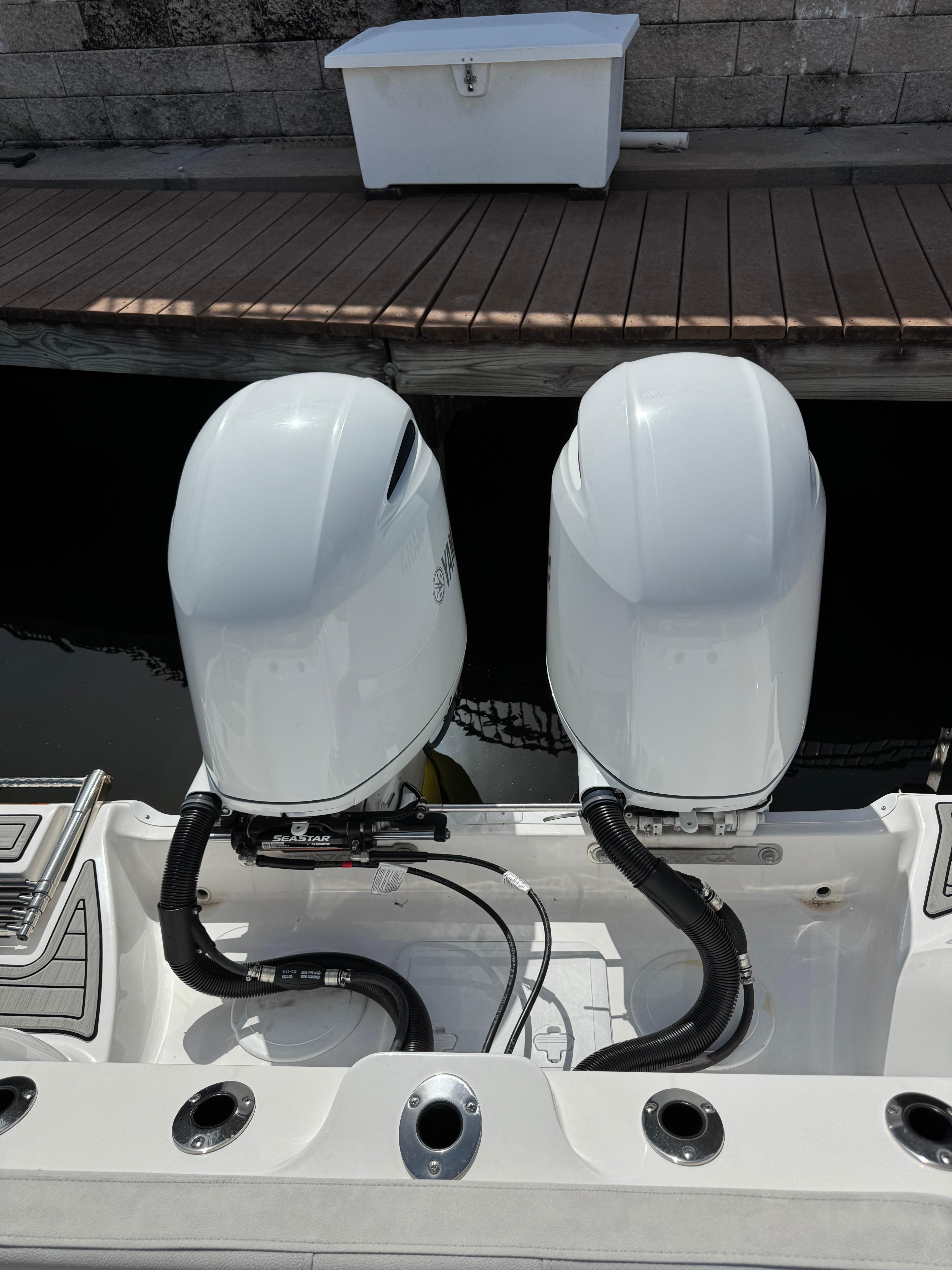 Twin outboard engines on a 2023 Sea Fox 268 Commander boat at a dock.