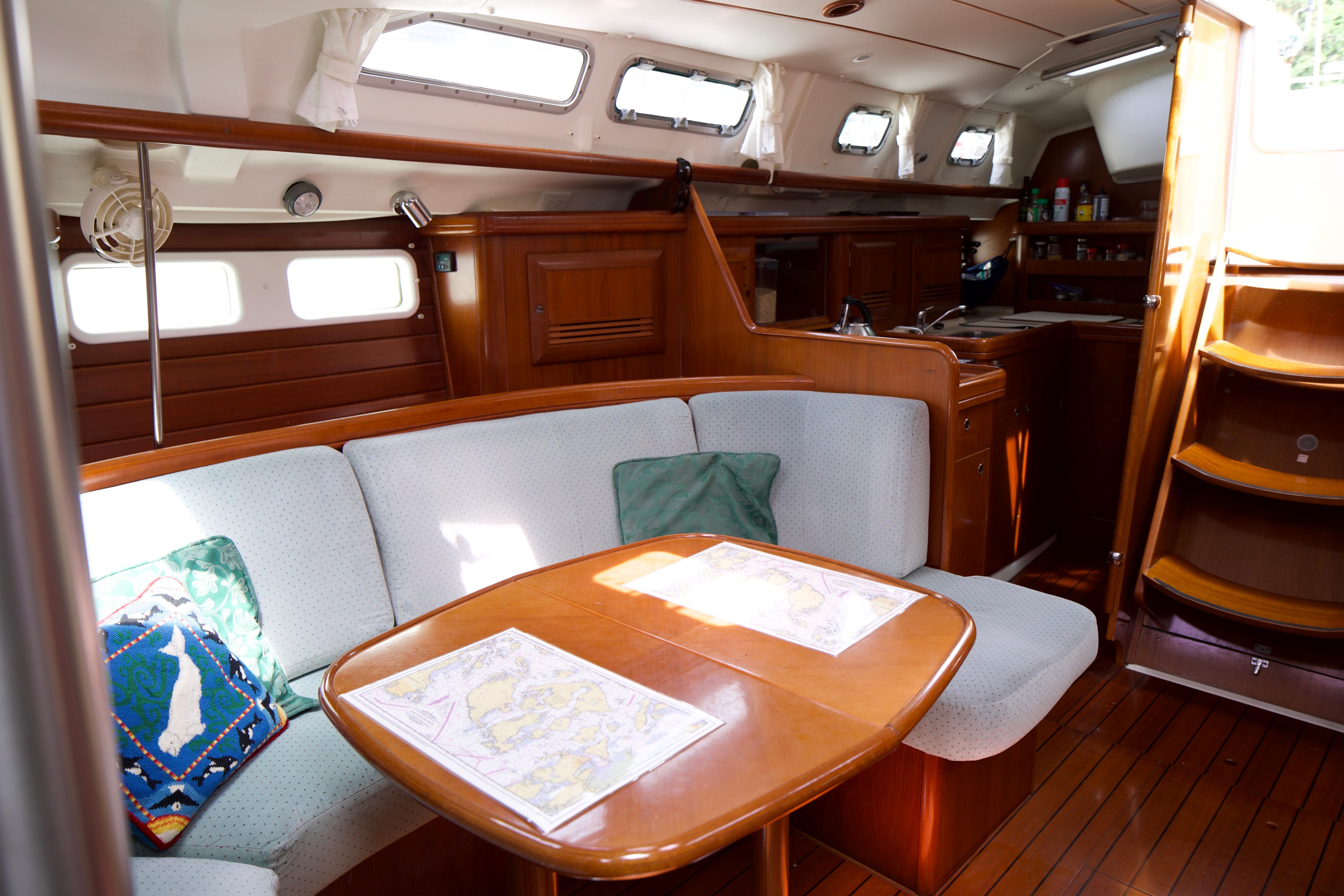 Interior of 2005 Beneteau 423 sailboat with cozy seating and wooden finishes.