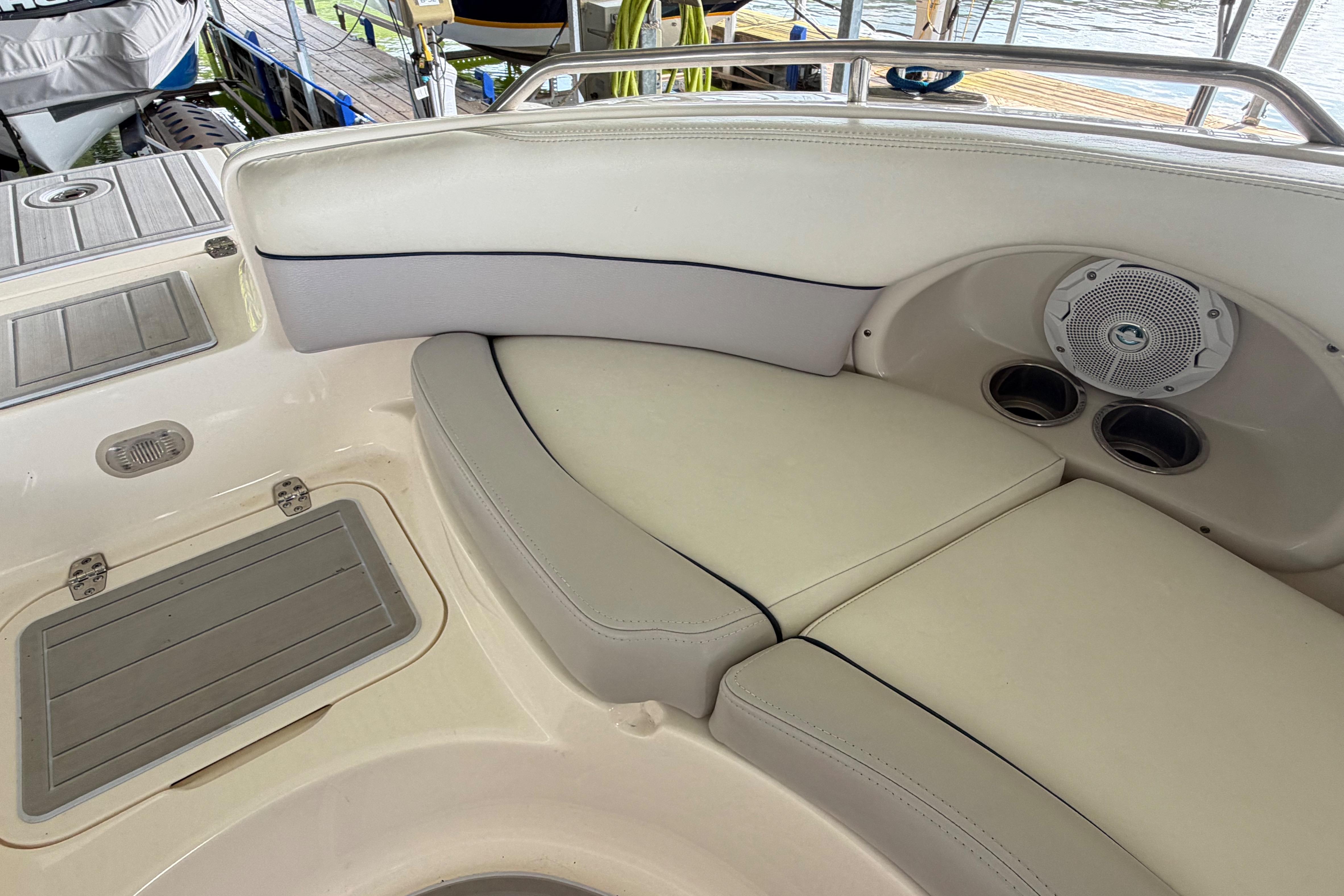 Interior of a 2010 Bryant 255 boat featuring cushioned seating and built-in speakers.