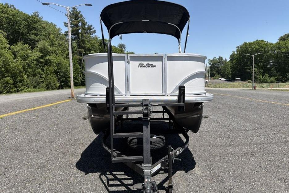 2026 Sun Tracker Party Barge 18 DLX on trailer, parked on a sunny road.