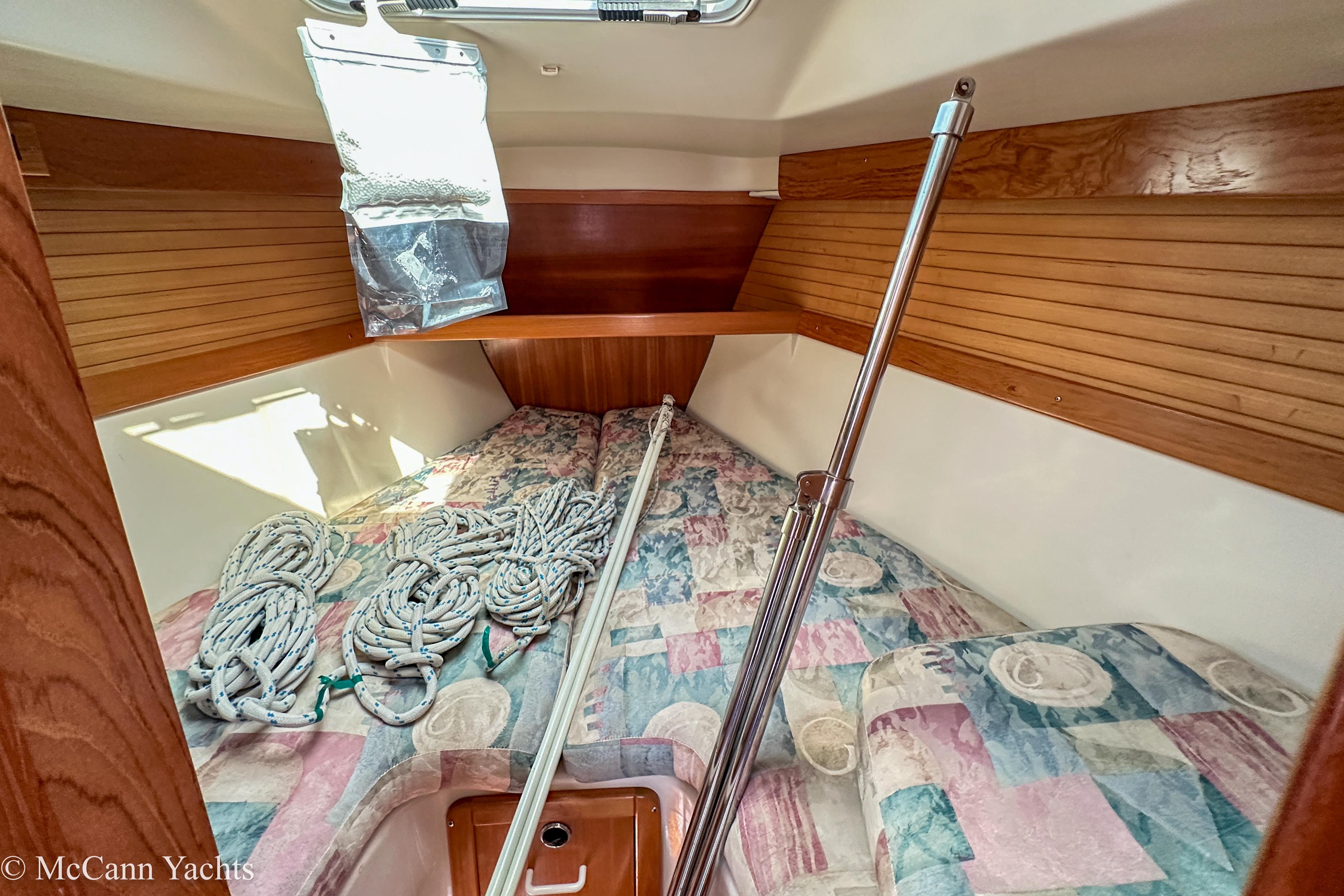 2003 Catalina 320 yacht interior with ropes and colorful bedding.