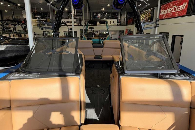 2026 Moomba Tykon boat interior with tan seating and modern design in showroom.