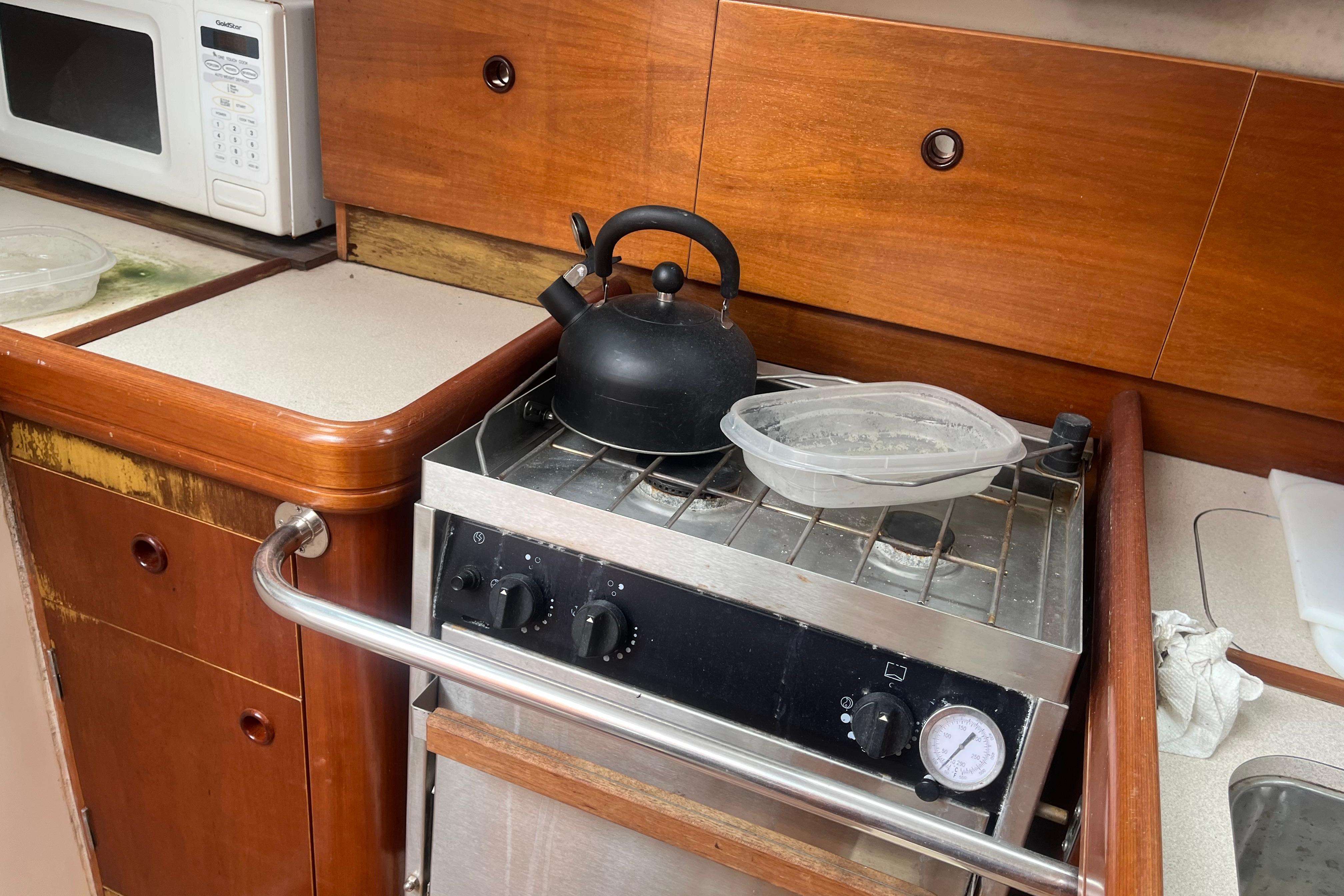 Galley kitchen in 1999 Benneteau 321 Oceanis sailboat with stove and kettle.