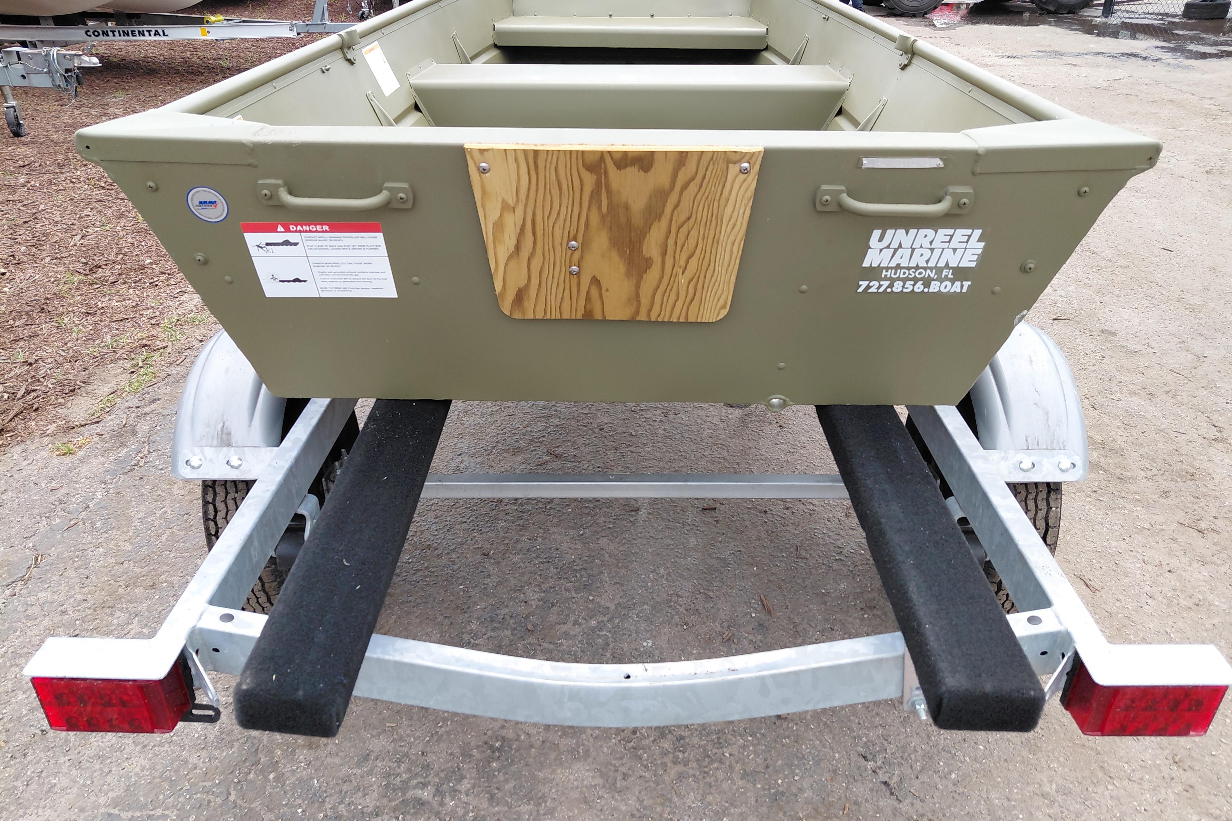 2025 Lowe L1040 Jon boat on trailer, featuring durable construction and safety warnings.