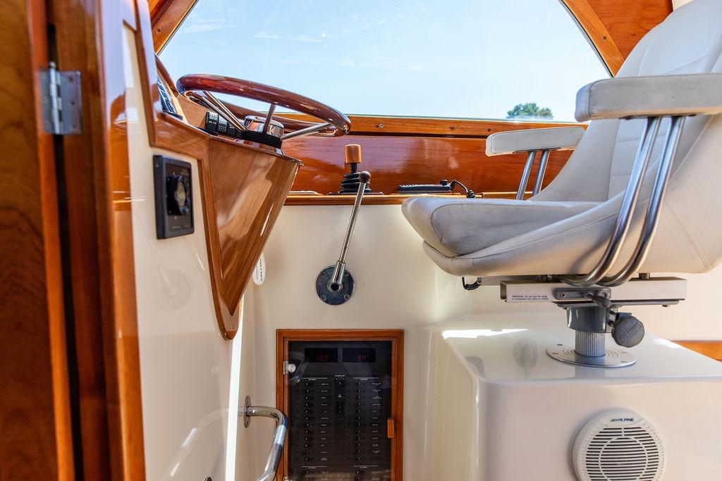 Interior helm of 2000 Hinckley Picnic Boat 36 Classic with steering wheel and captain's chair.