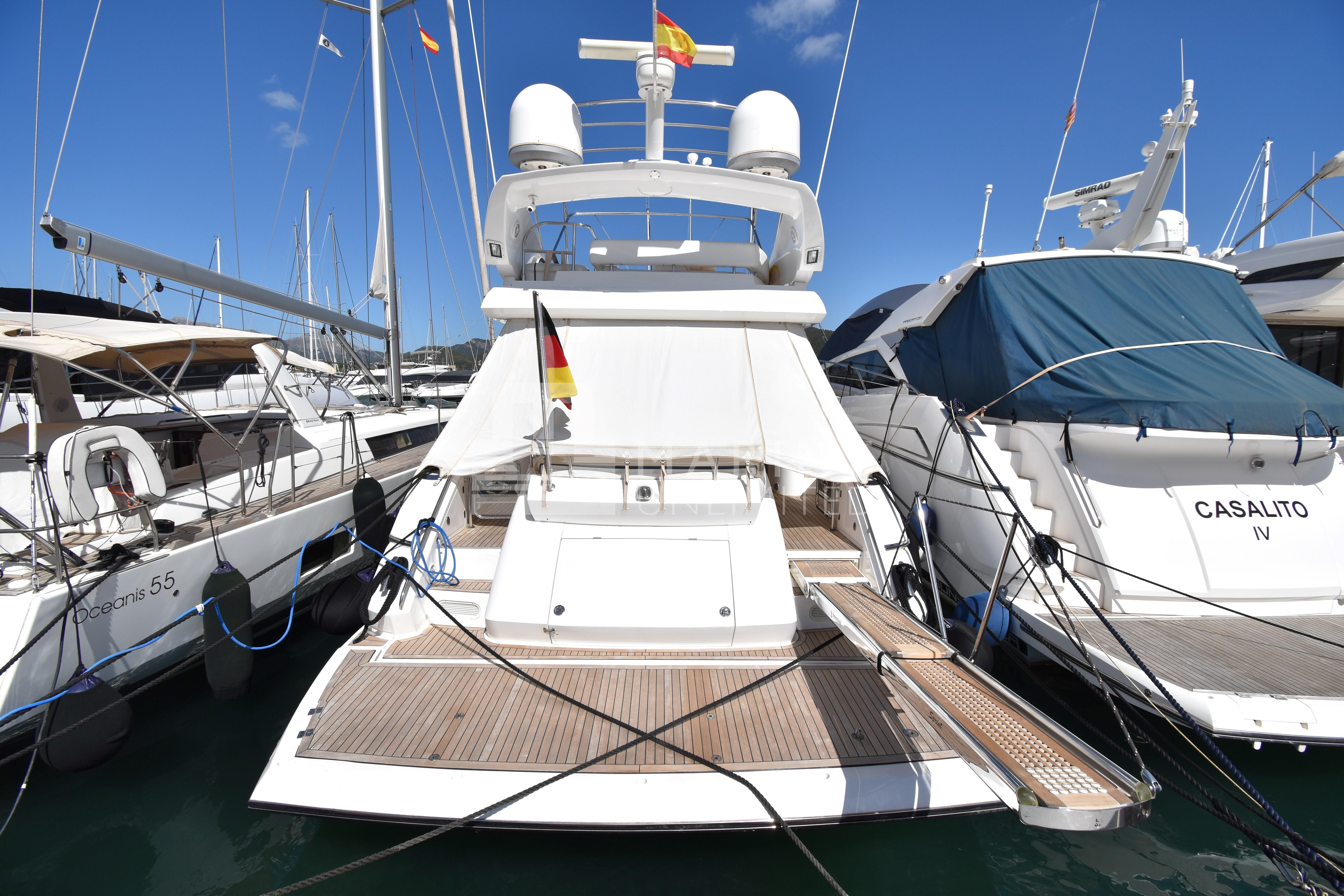 Sunseeker Manhattan 52 yacht, 2010 model, docked at marina with clear blue sky.