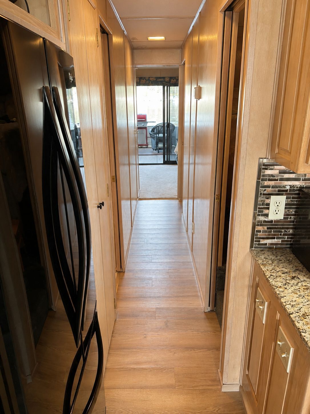 Interior view of a houseboat with wooden floors and a modern kitchen.