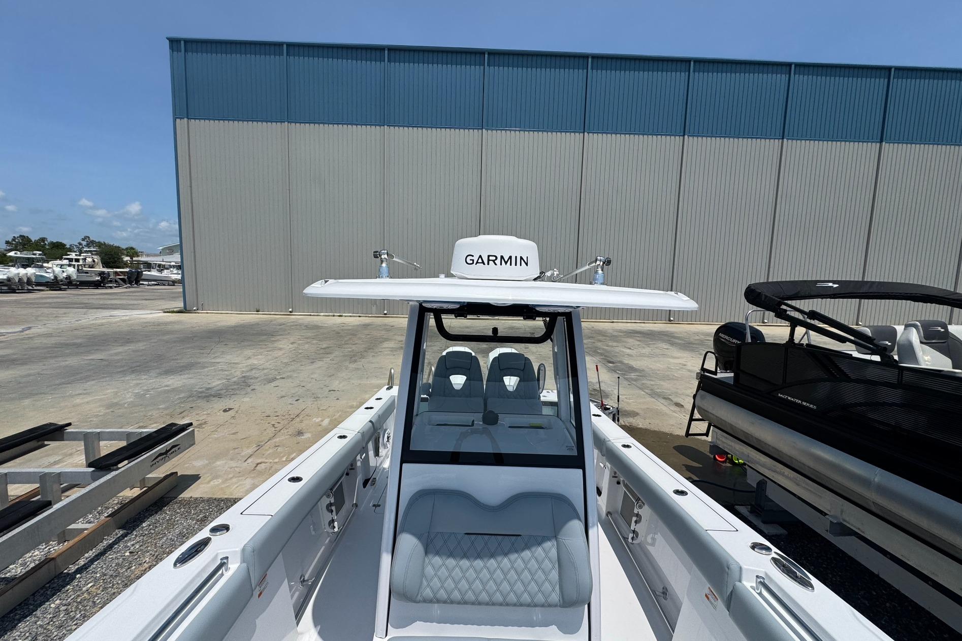 2026 Sportsman Open 262 Center Console boat with Garmin equipment, docked outdoors.