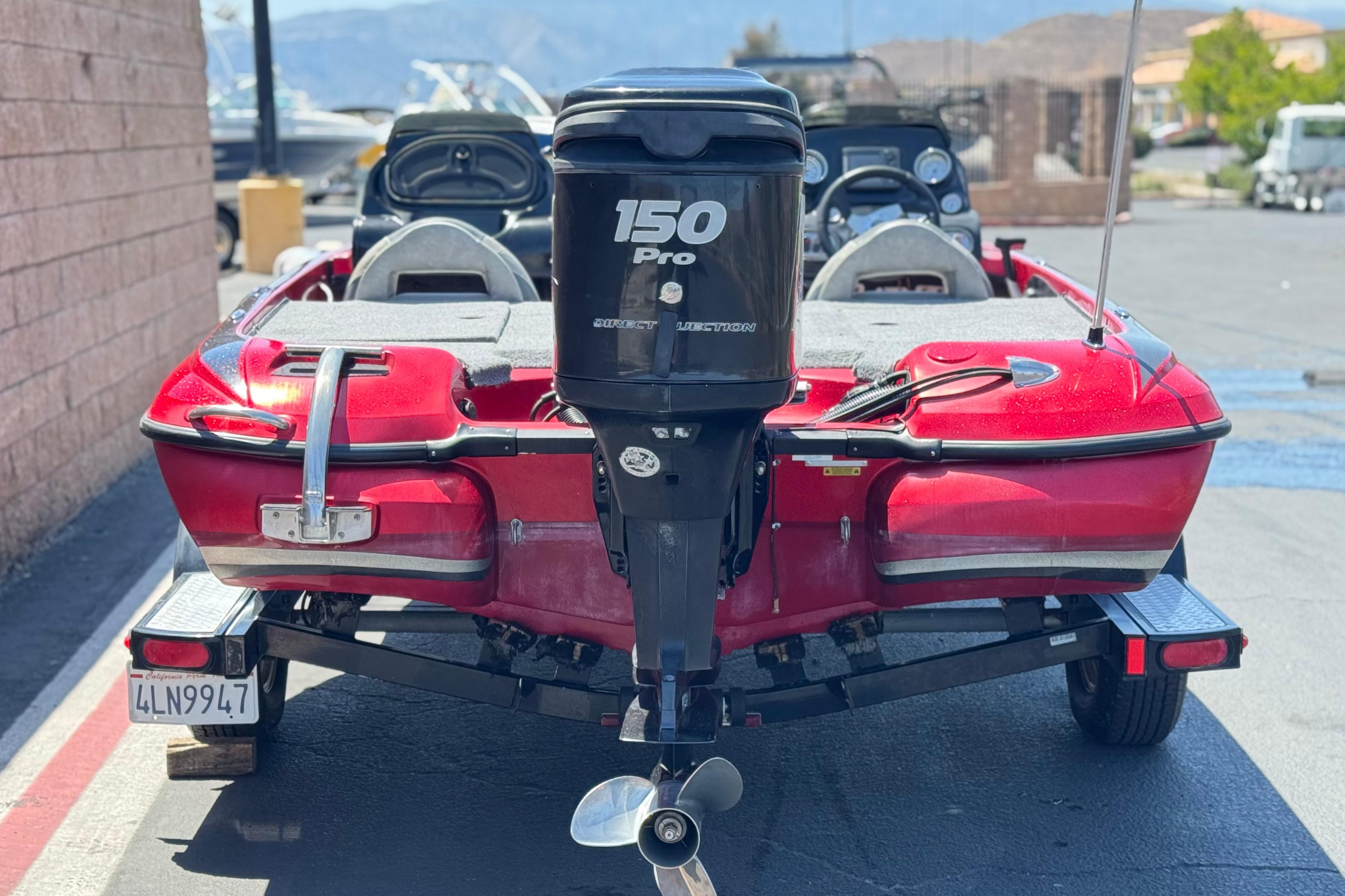 Red 2012 Nitro Z-7 boat with 150 Pro outboard motor on trailer.