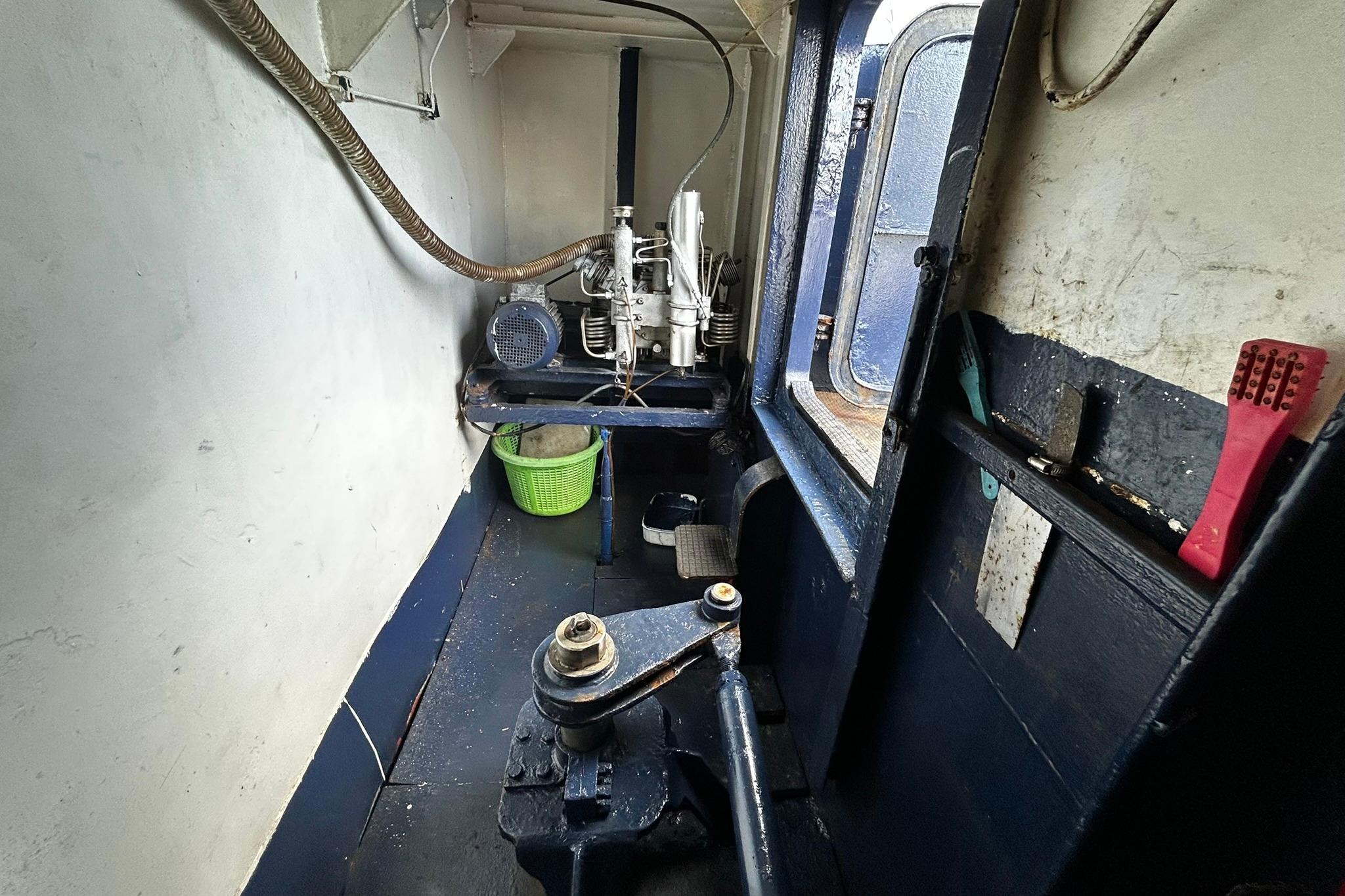 Interior of a 1999 Custom 28M vessel engine room with machinery and tools.