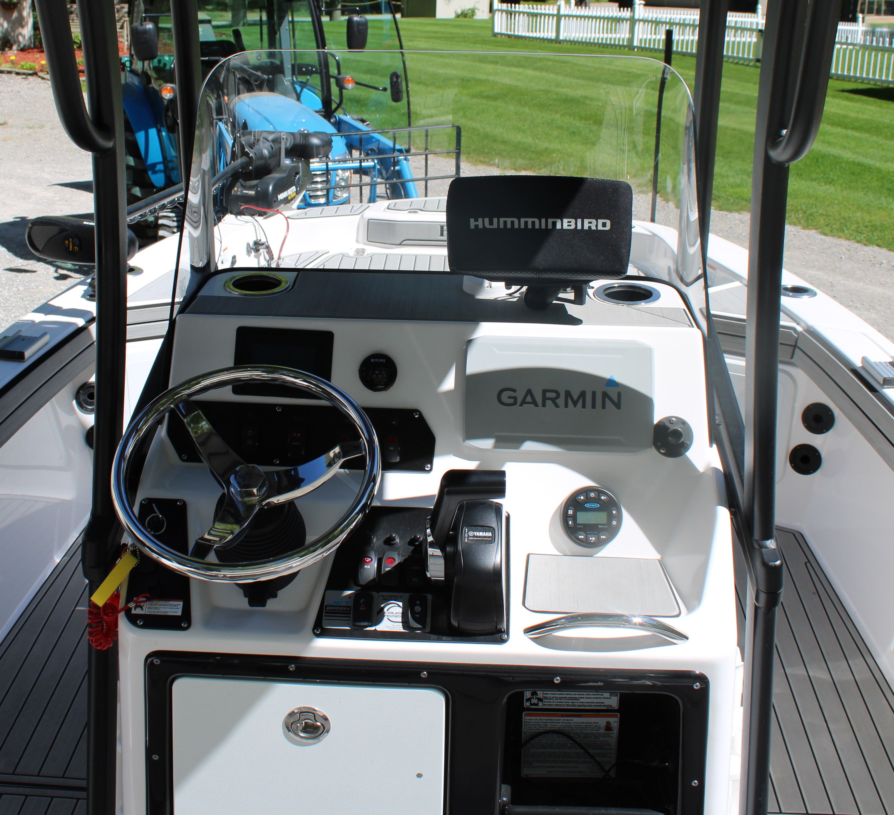 The image shows the cockpit of a Yamaha 190 FSH Sport boat with steering and electronics.