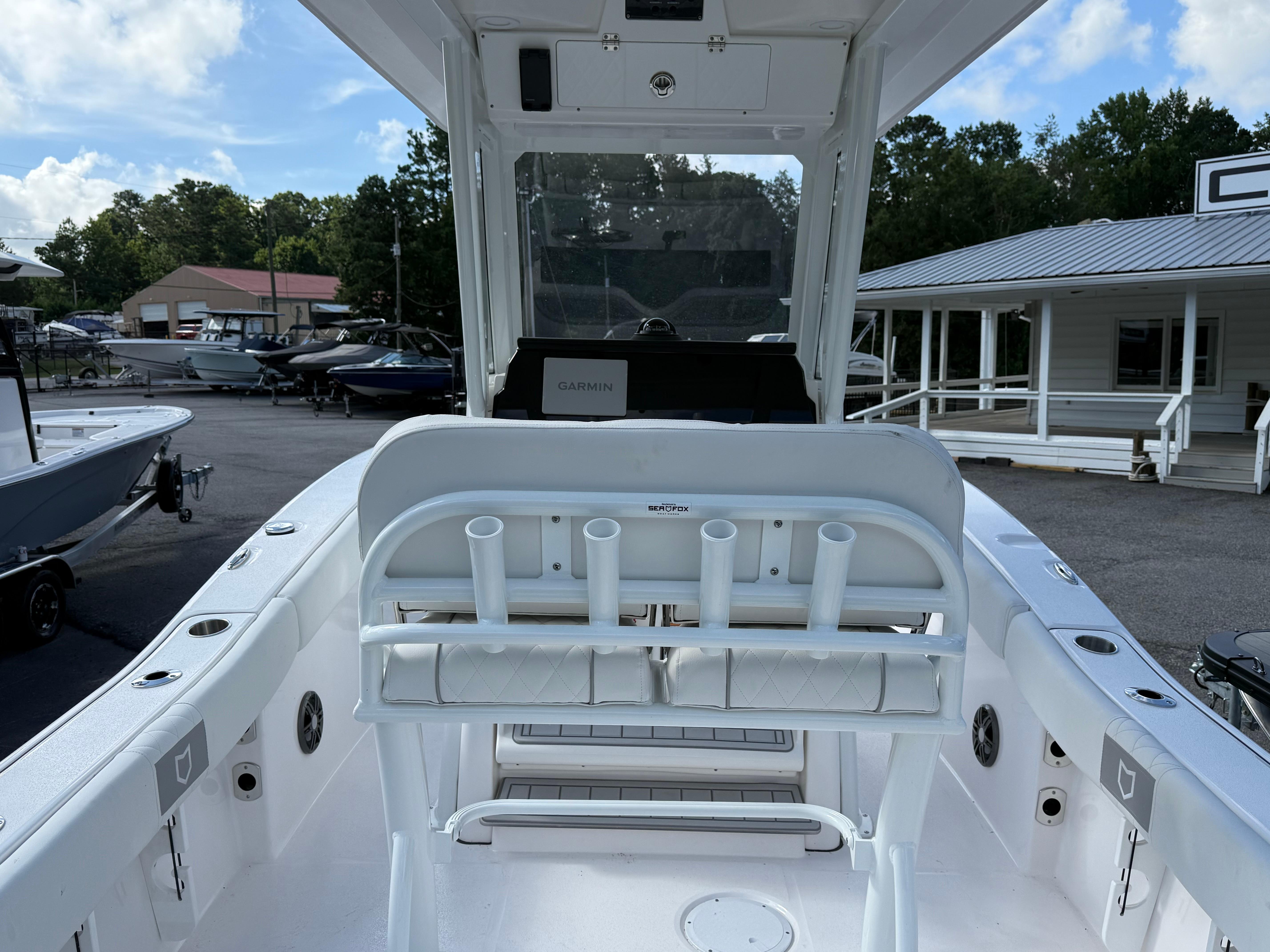 2026 Sea Fox 228 Commander boat interior with rod holders and Garmin equipment, docked outdoors.