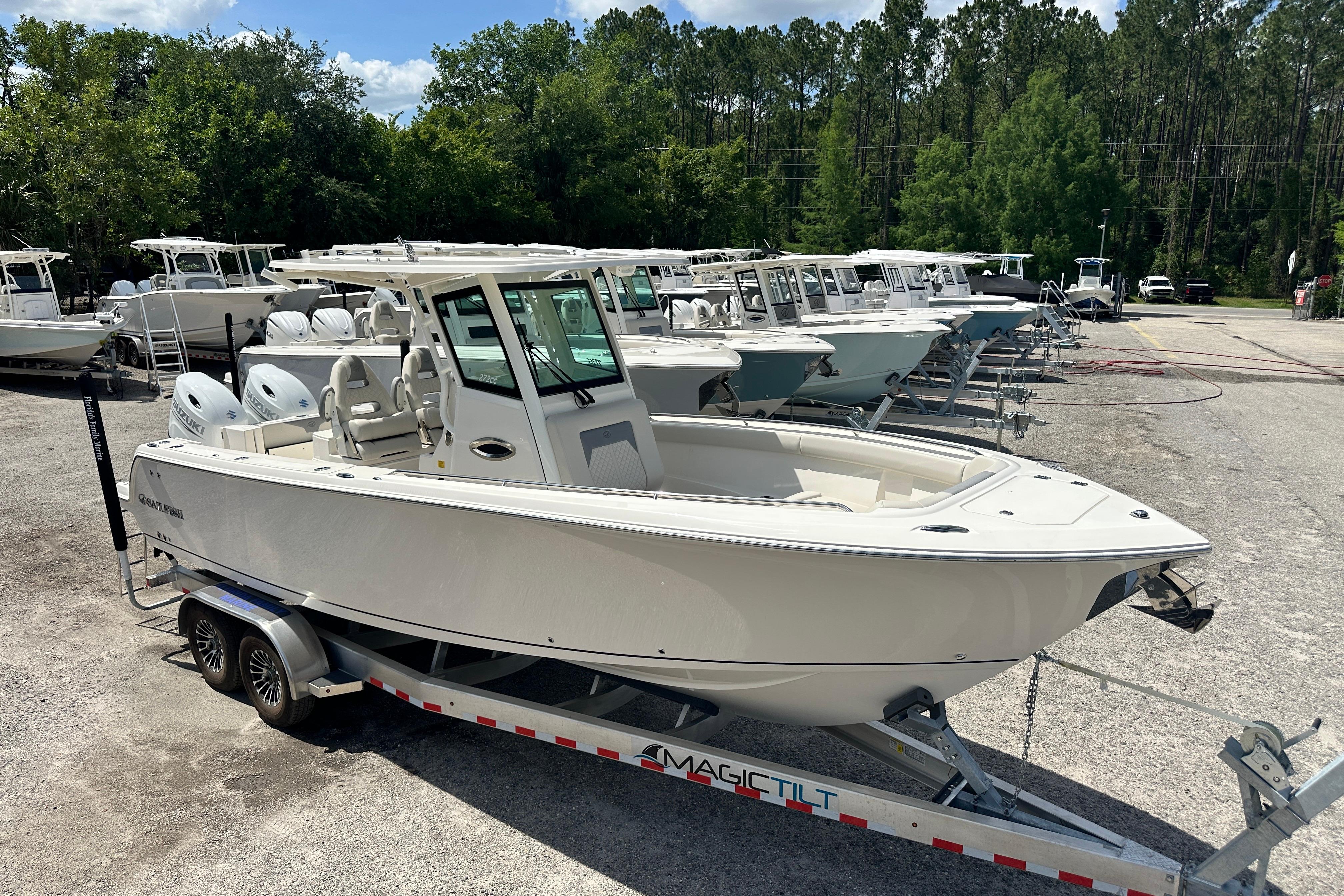 2026 Sailfish 272 CC boat on trailer in dealership lot, surrounded by trees.