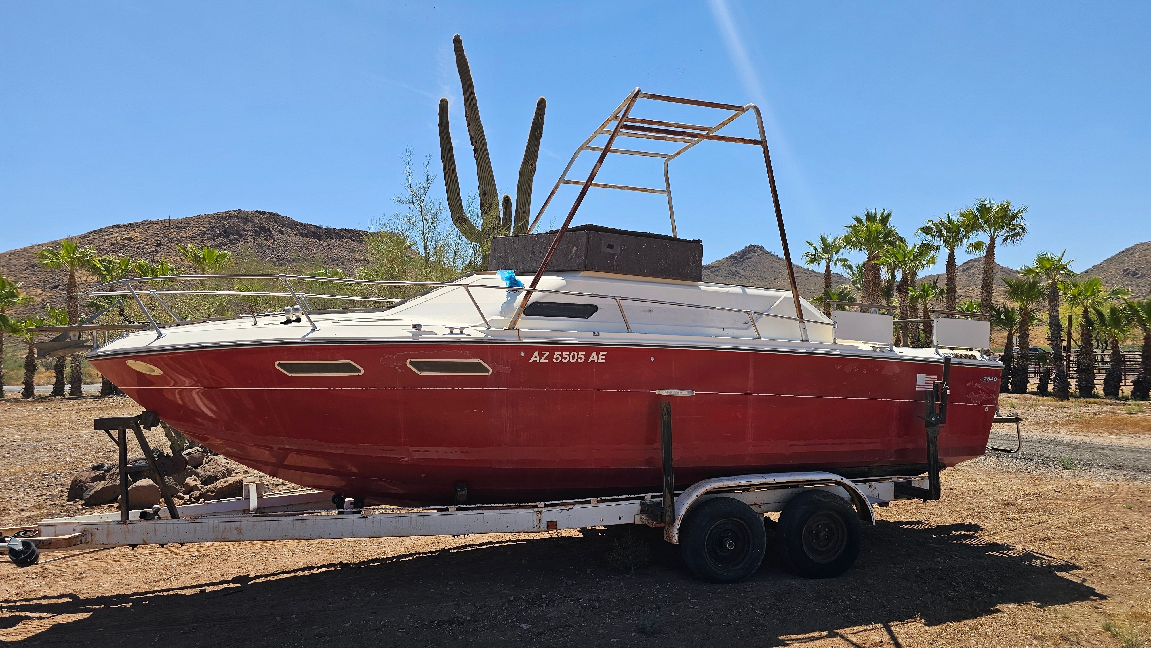 1975 Sea Ray Cabin Cruiser on trailer in desert landscape.
