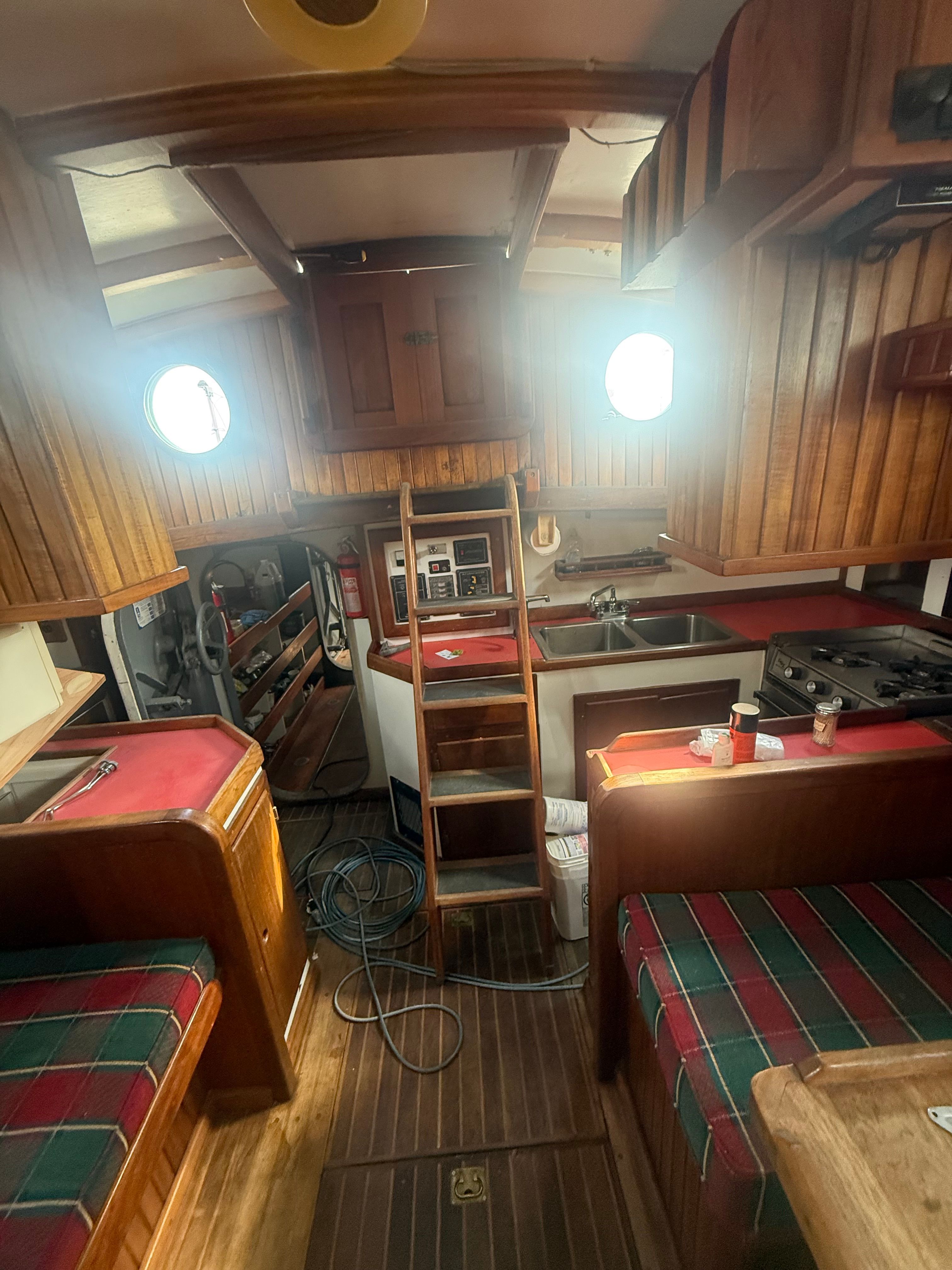 Interior of a classic sailboat with wooden fittings and cozy seating areas.