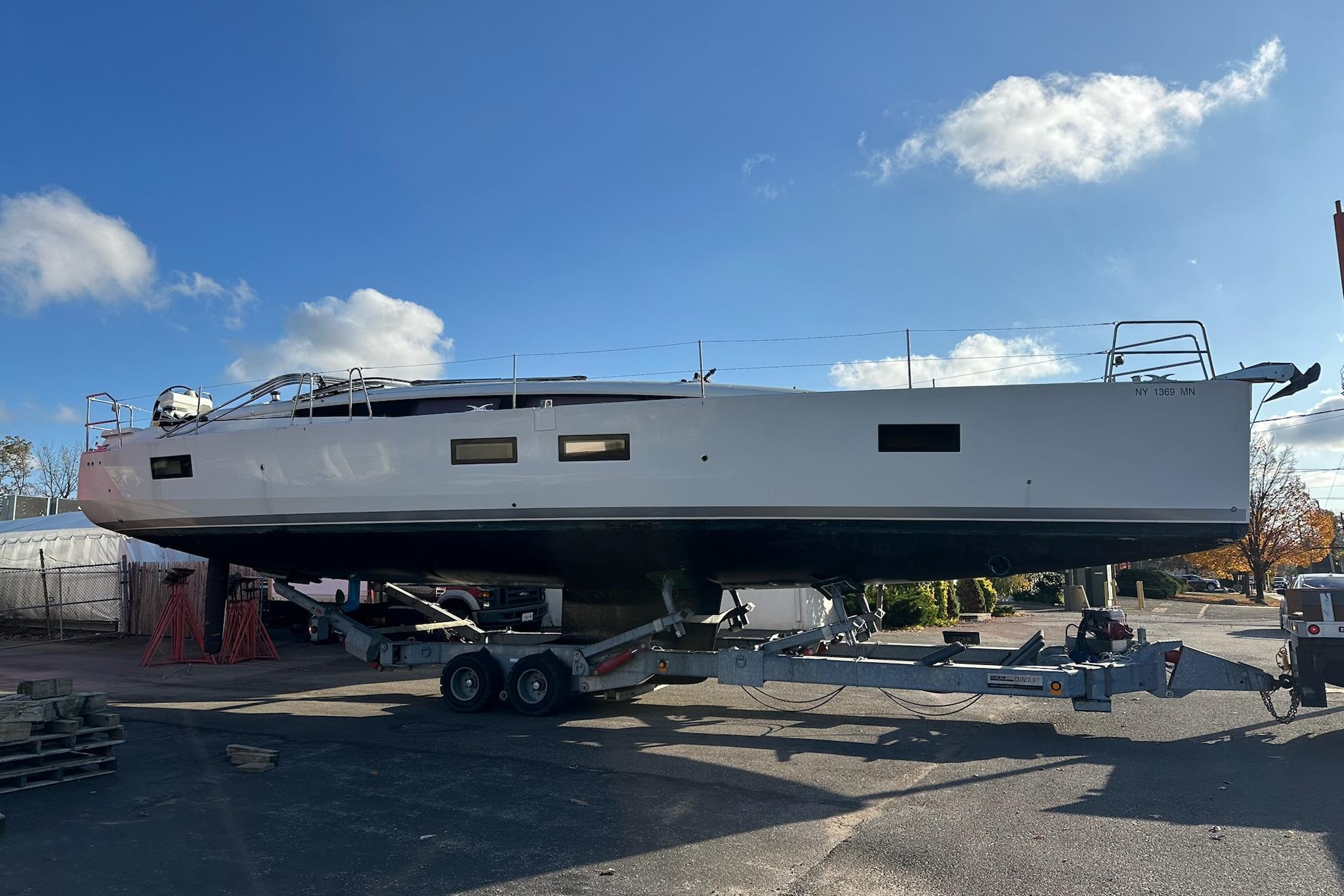 2018 Jeanneau 51 yacht on trailer under clear blue sky.