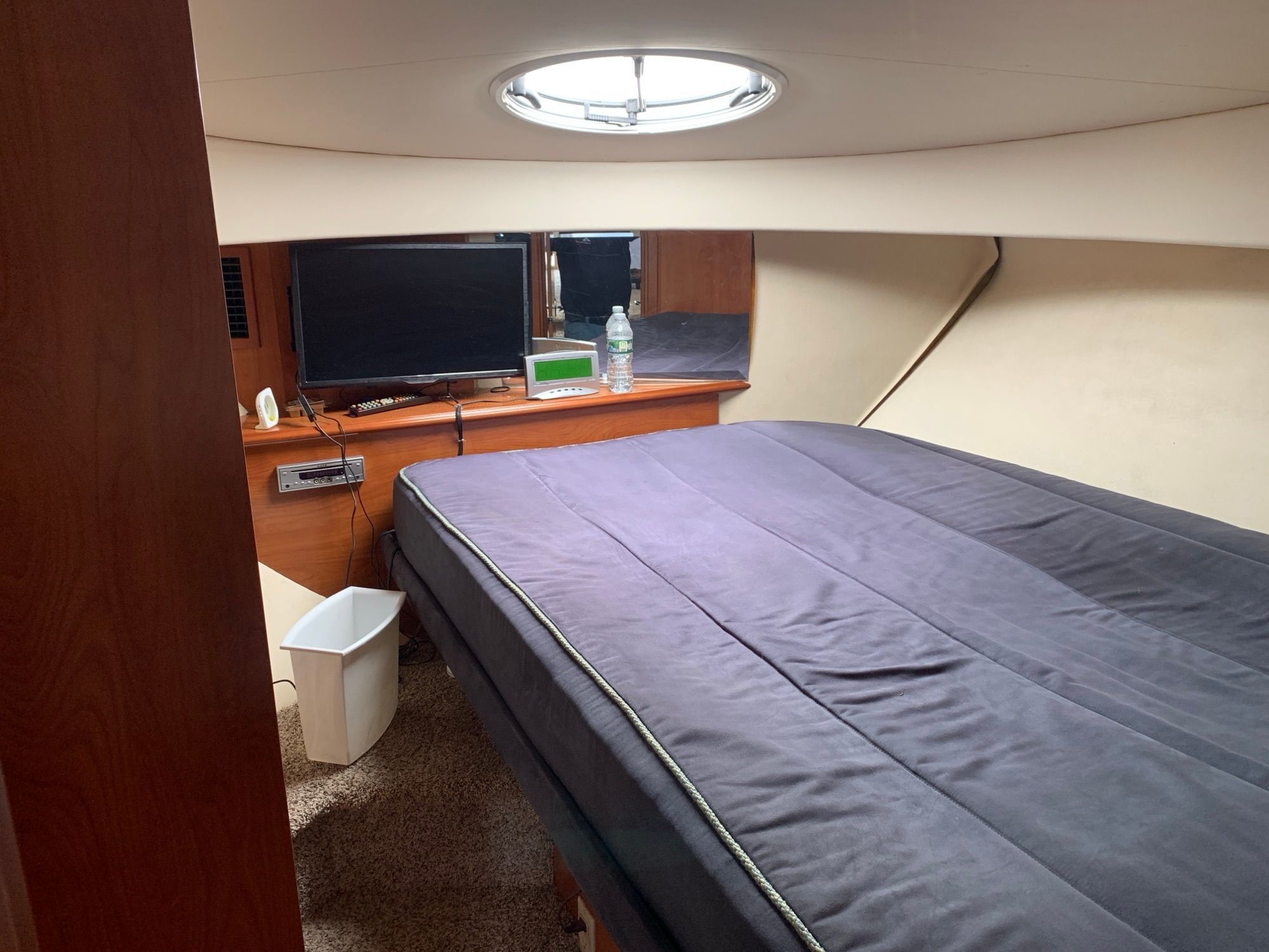 Interior of a Silverton 33 Convertible with bed, TV, and porthole.