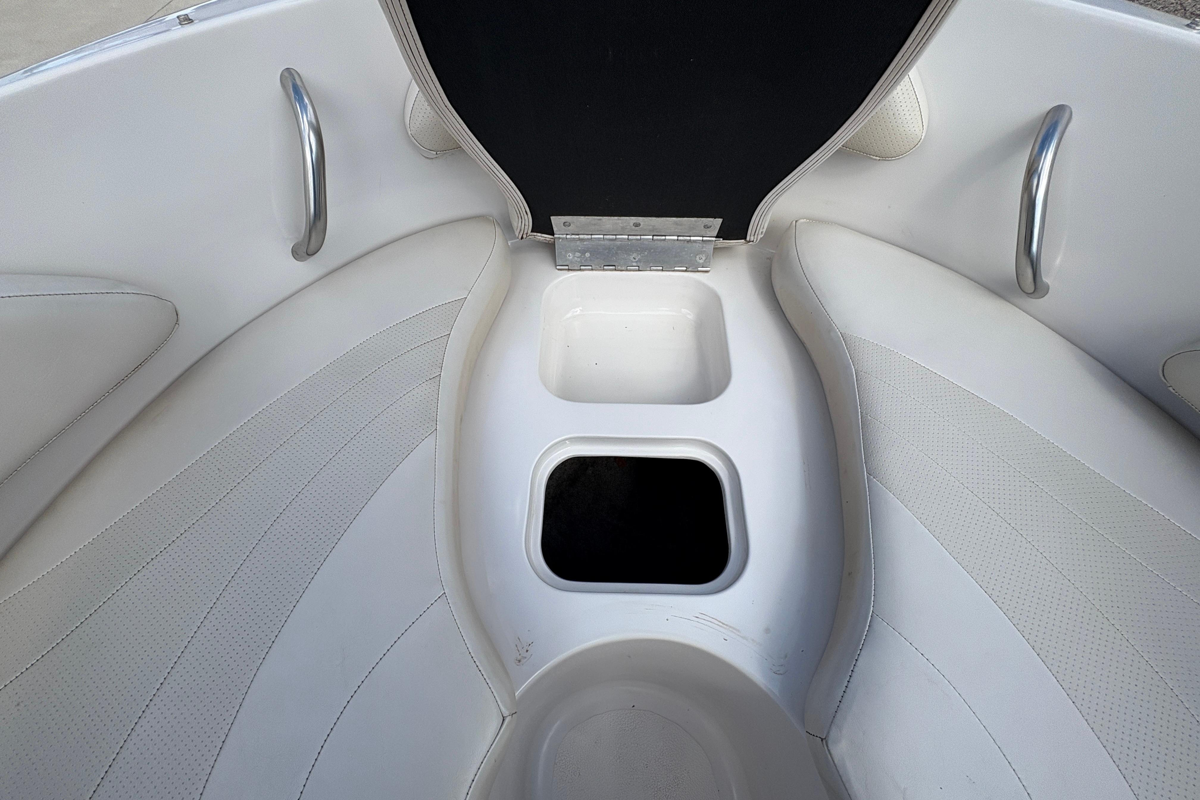 Interior view of a 2005 Starcraft C-Star 1700 OB boat, featuring white seating and storage compartments.
