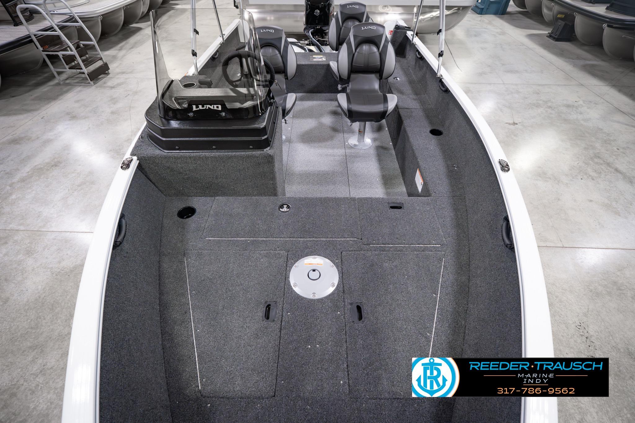 2026 Lund 1650 Rebel XL SS boat interior with seating and steering console in showroom.