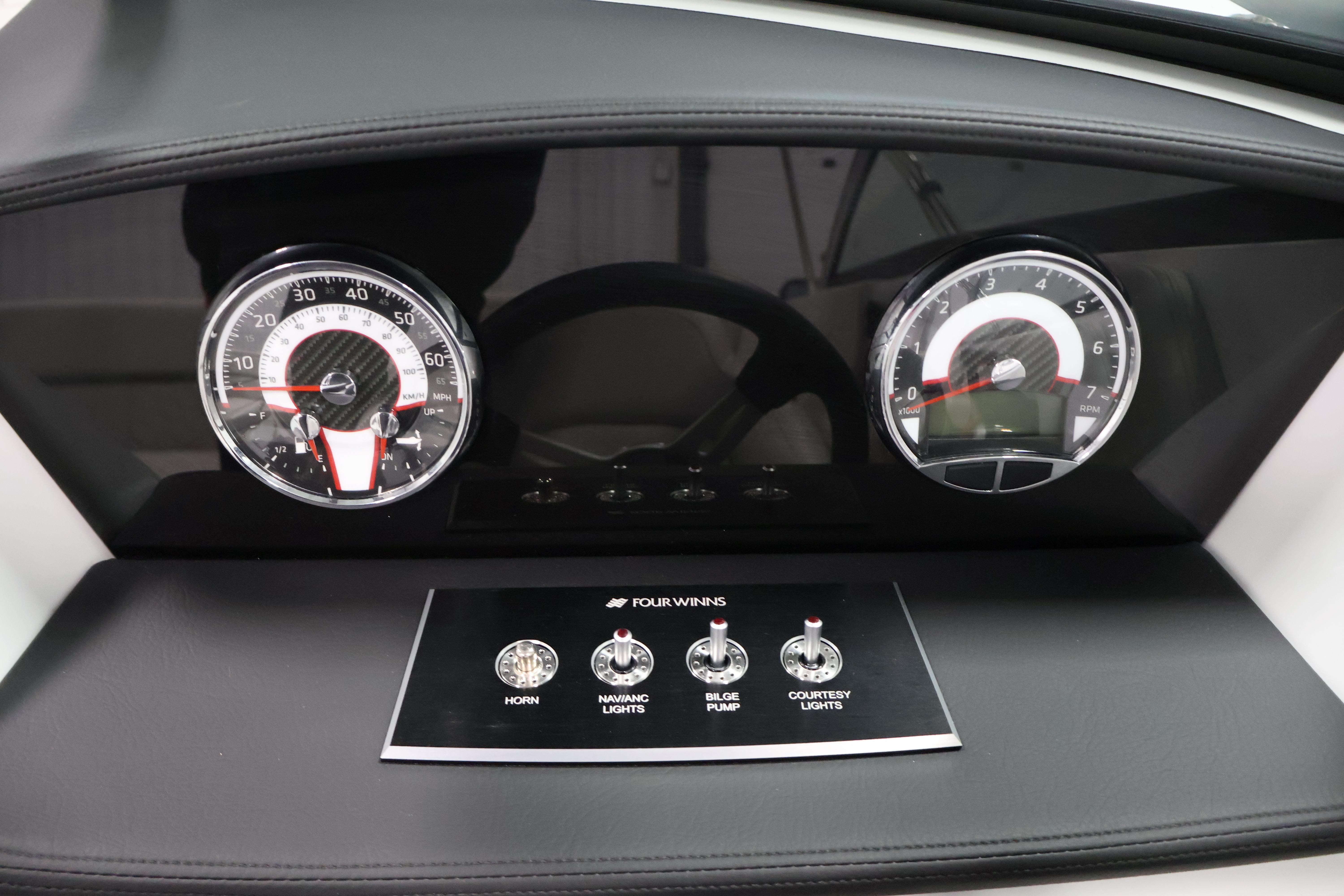 Dashboard of 2026 Four Winns H4 Freedom boat with gauges and control switches.