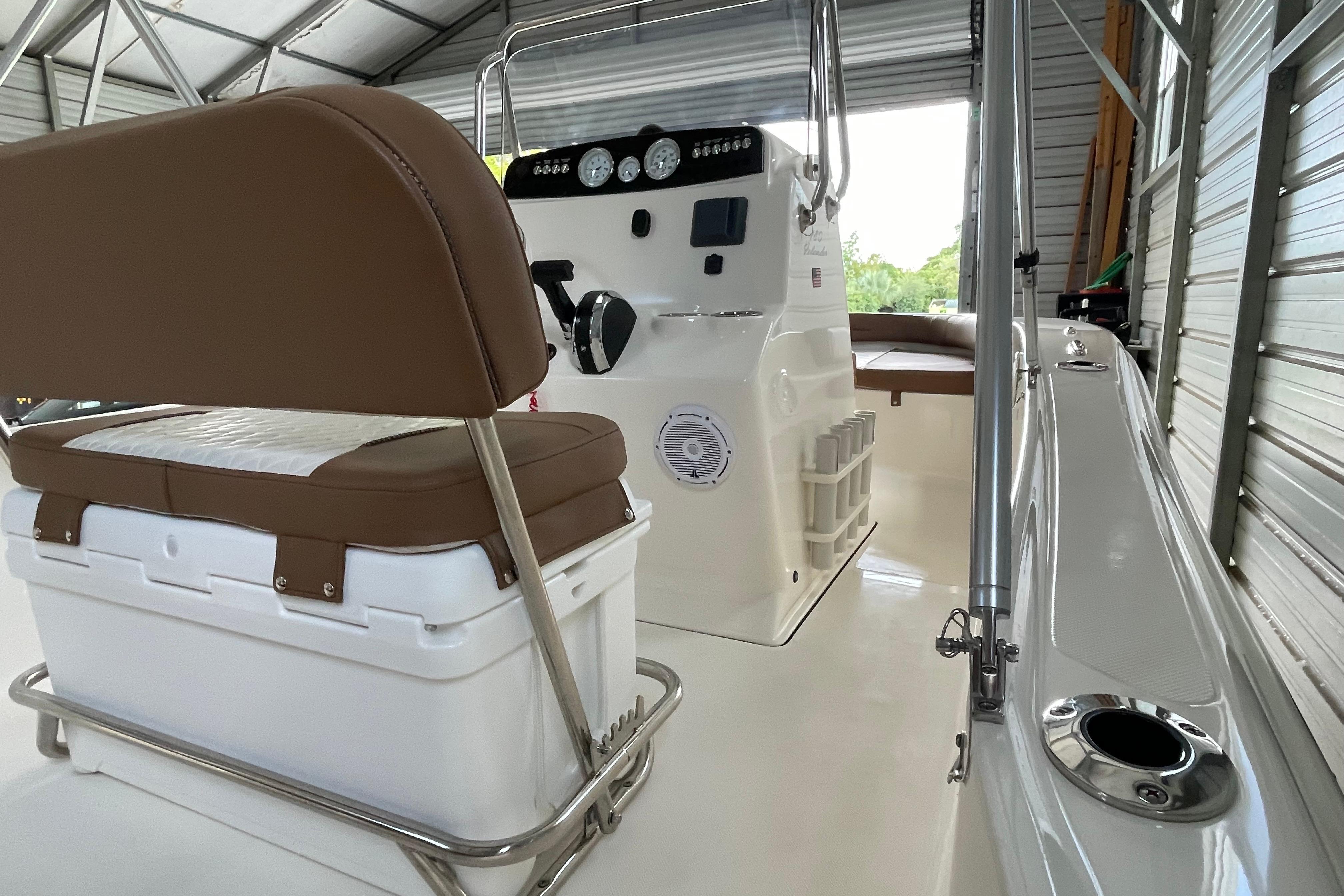2024 Pioneer 180 Islander boat interior with seating and control panel in a covered storage area.