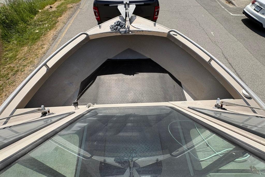 2009 Alumaweld Intruder Outboard 22 boat, viewed from above, parked on a roadside.