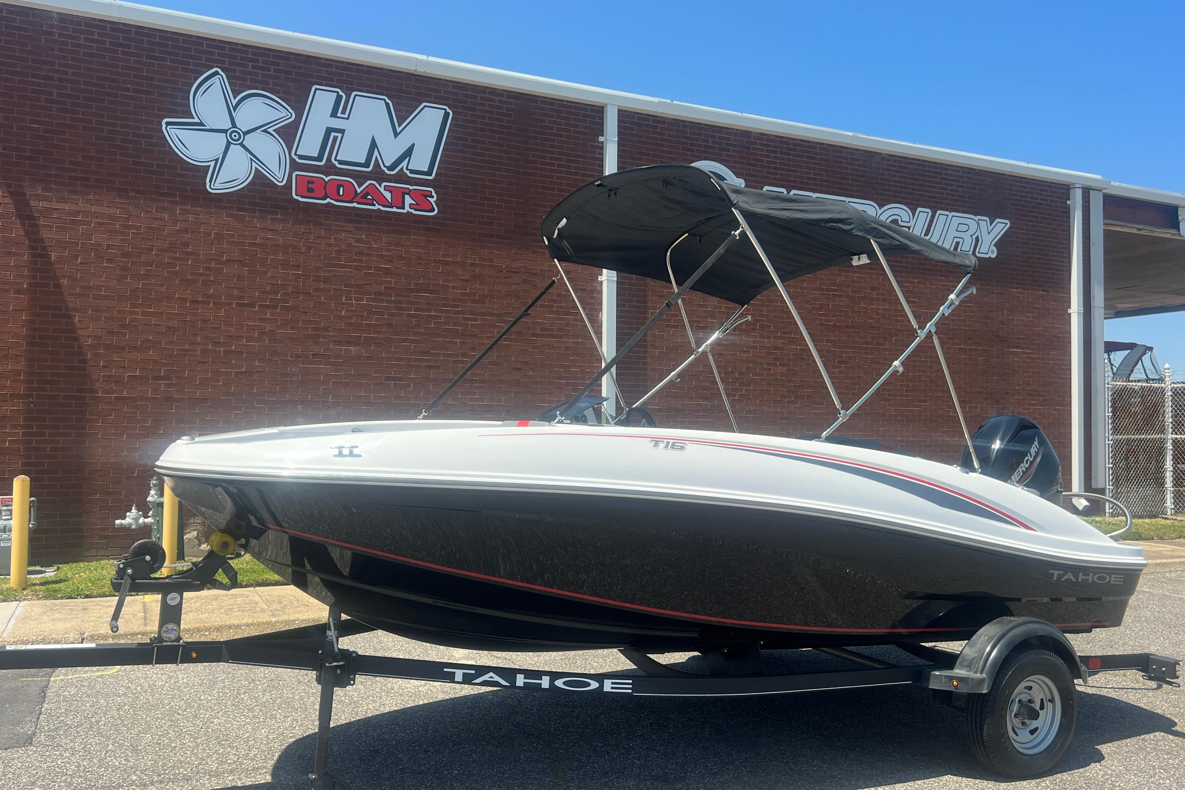 2023 Tahoe T16 boat on trailer outside HM Boats dealership.