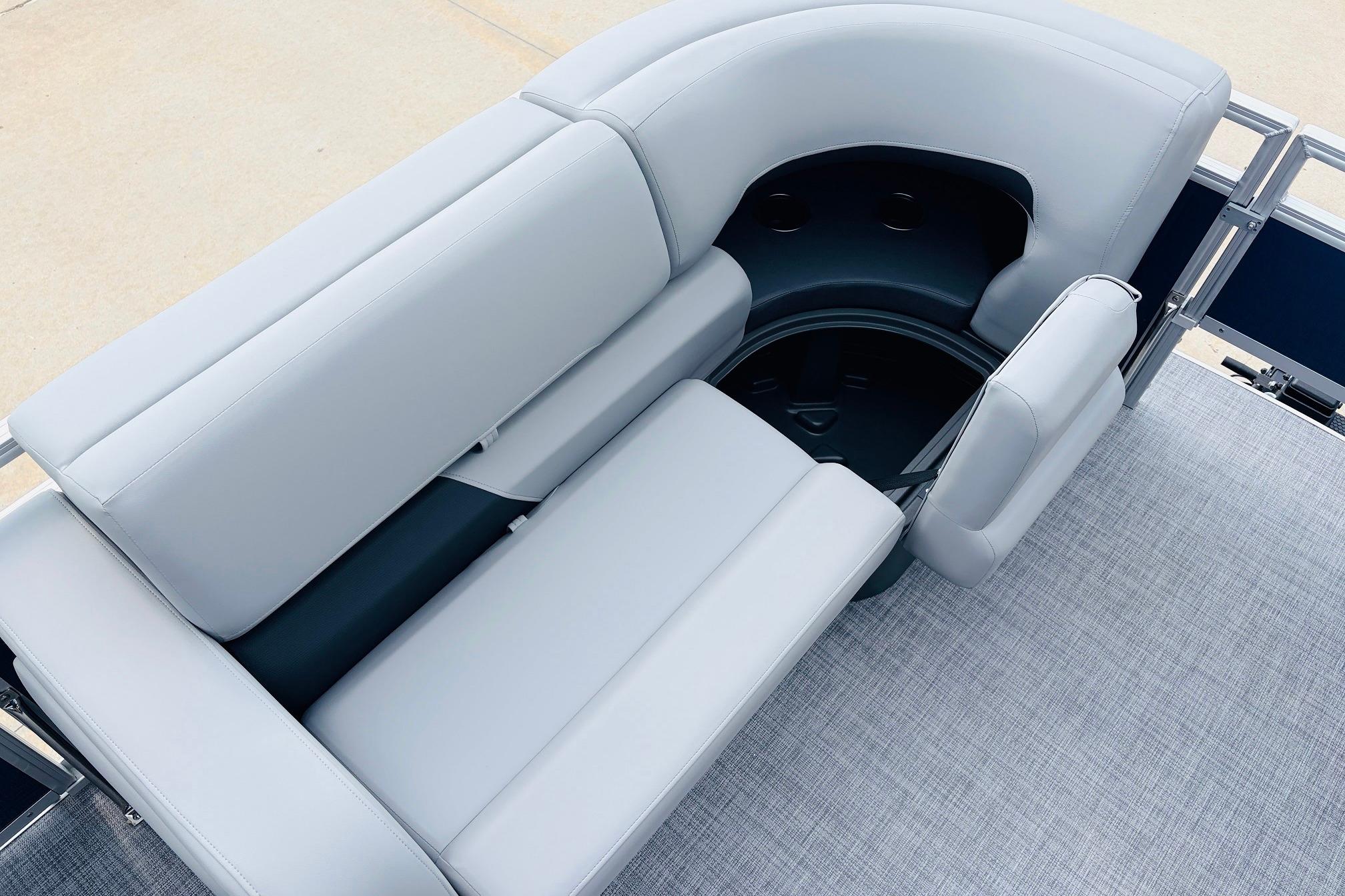 2026 Sun Tracker SportFish 22 DLX boat seating area with gray upholstery and storage compartment.