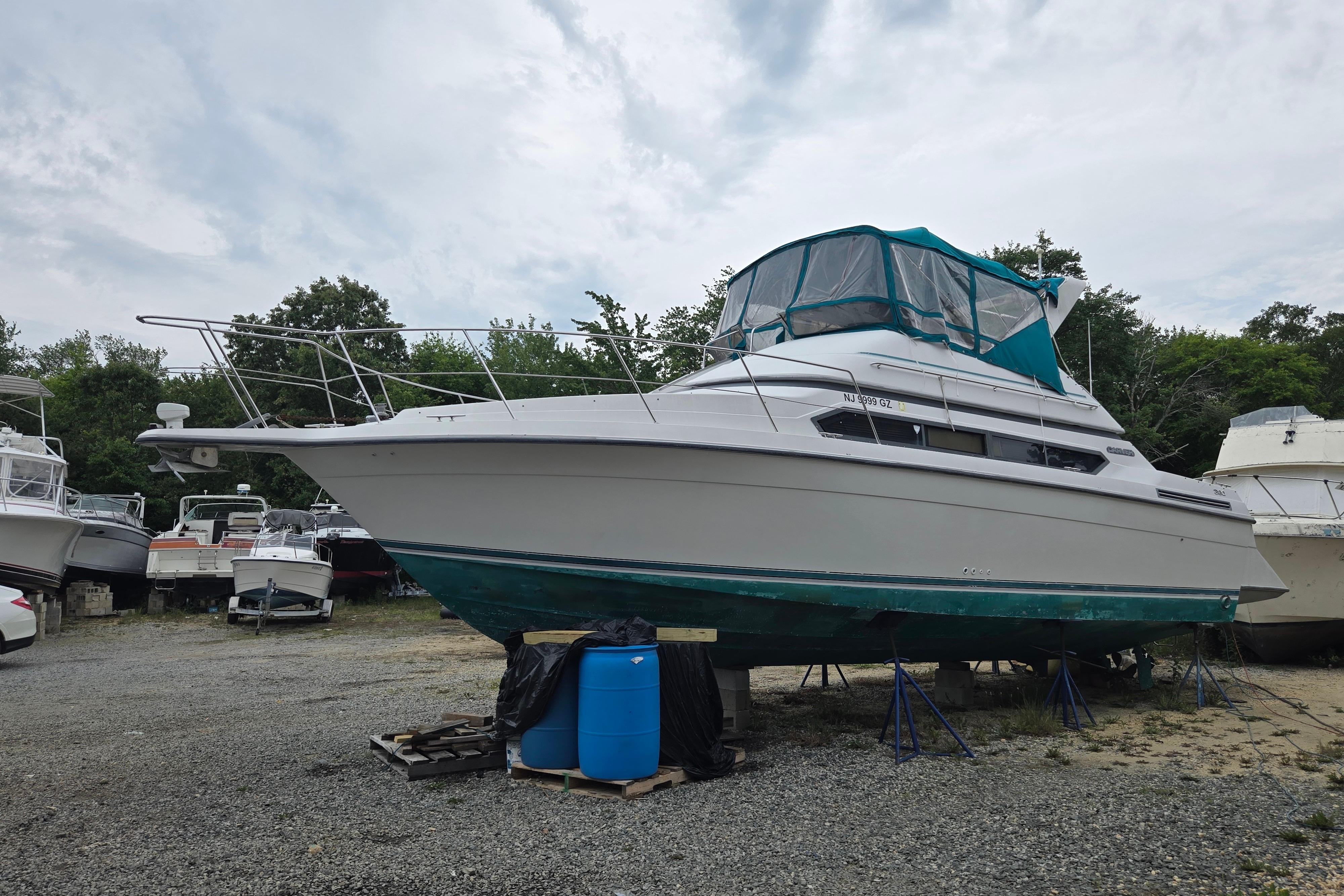 1994 Carver 380 Santego boat on dry dock, surrounded by trees and other vessels.