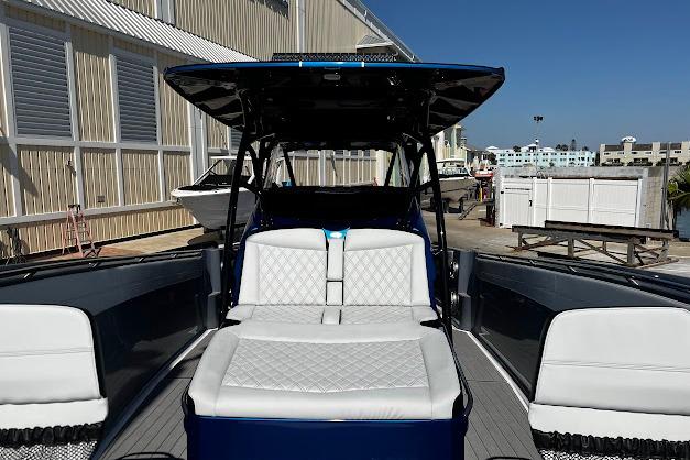 2022 Nor-Tech 390 Sport Center Console boat with white seating and sleek design at a marina.