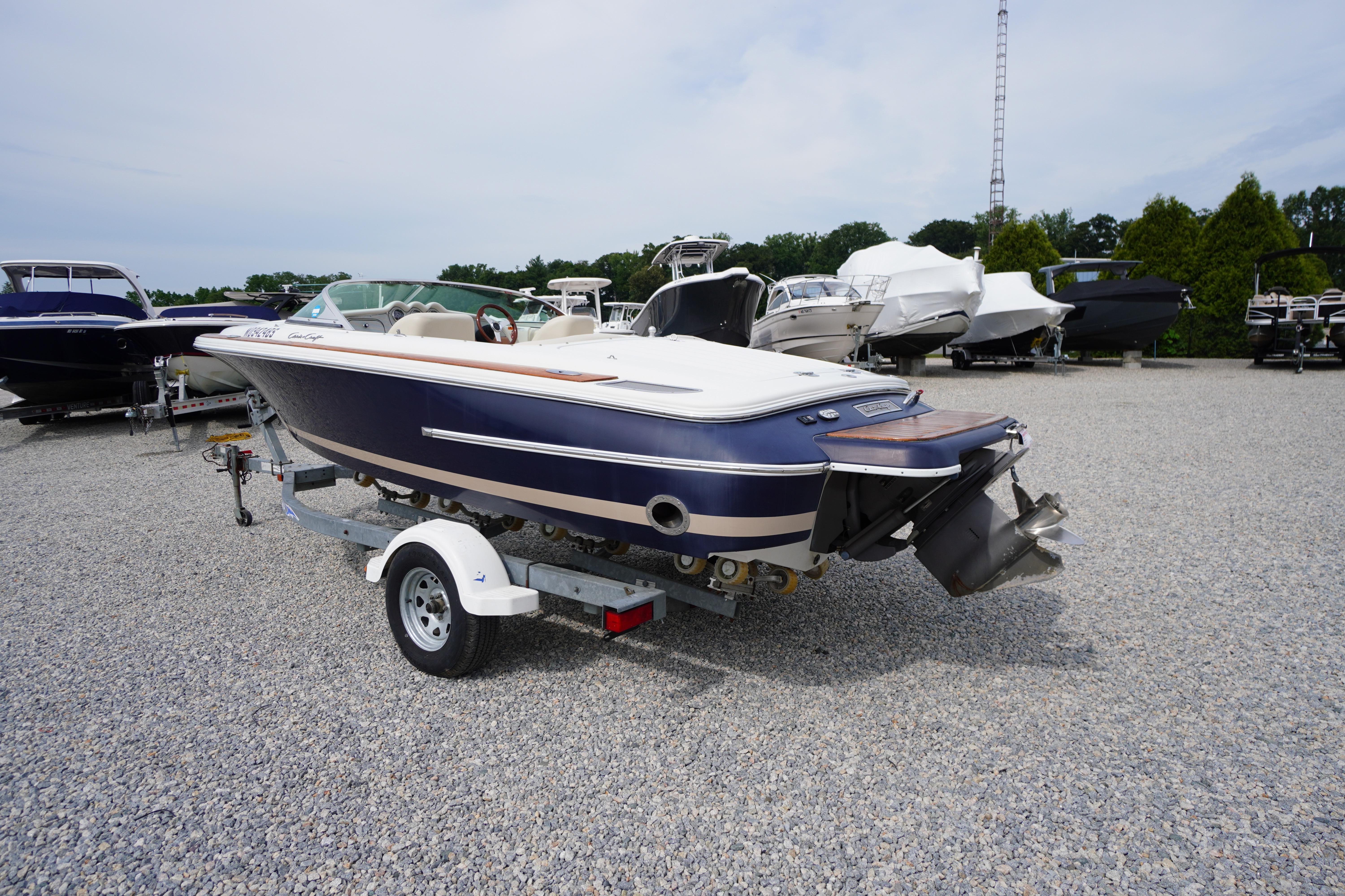 2005 Chris Craft Speedster Heritage boat on trailer in a marina setting.