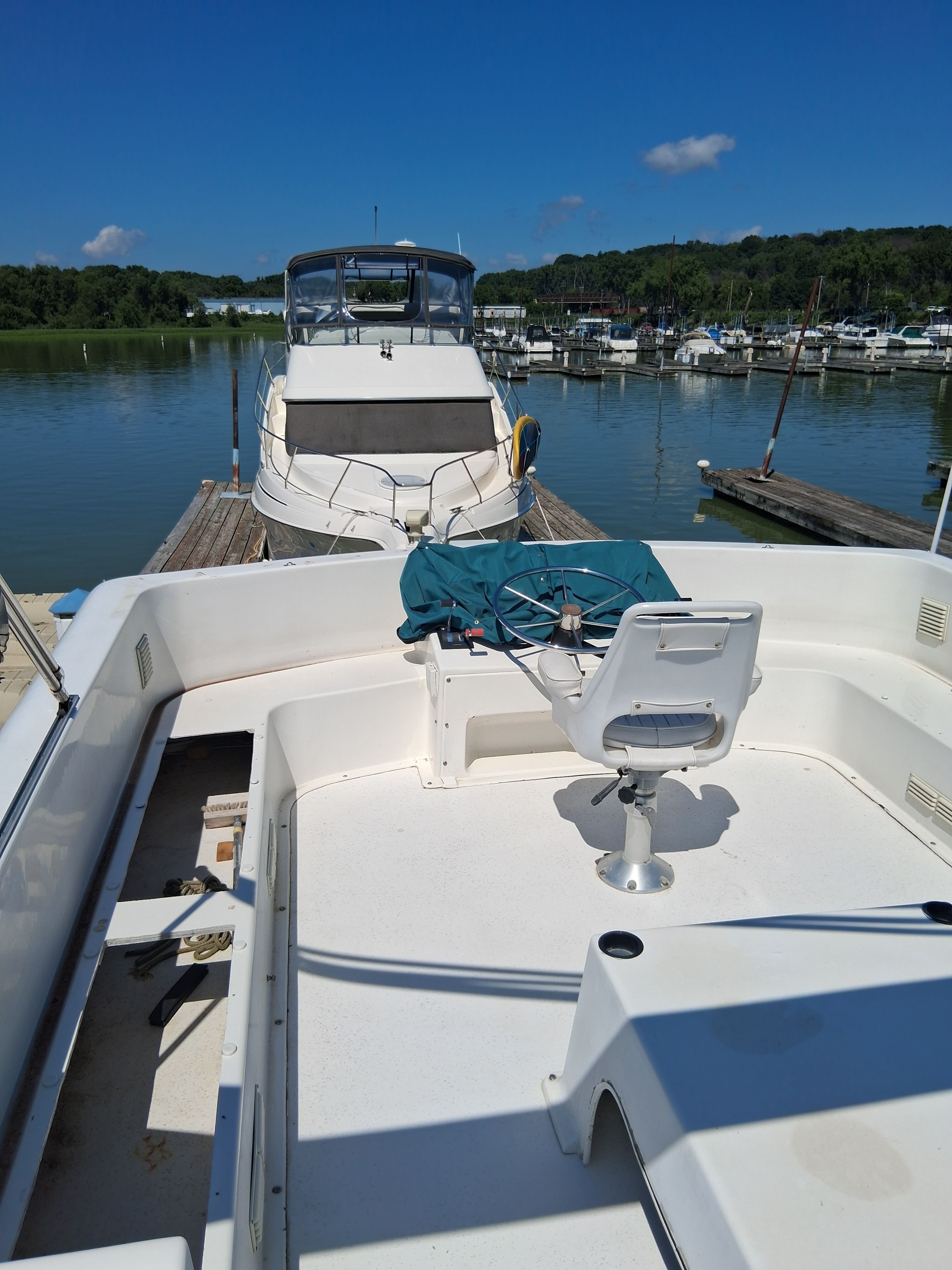 A 1993 Gibson 370 Sport at a calm dock, featuring a white seat on the deck.
